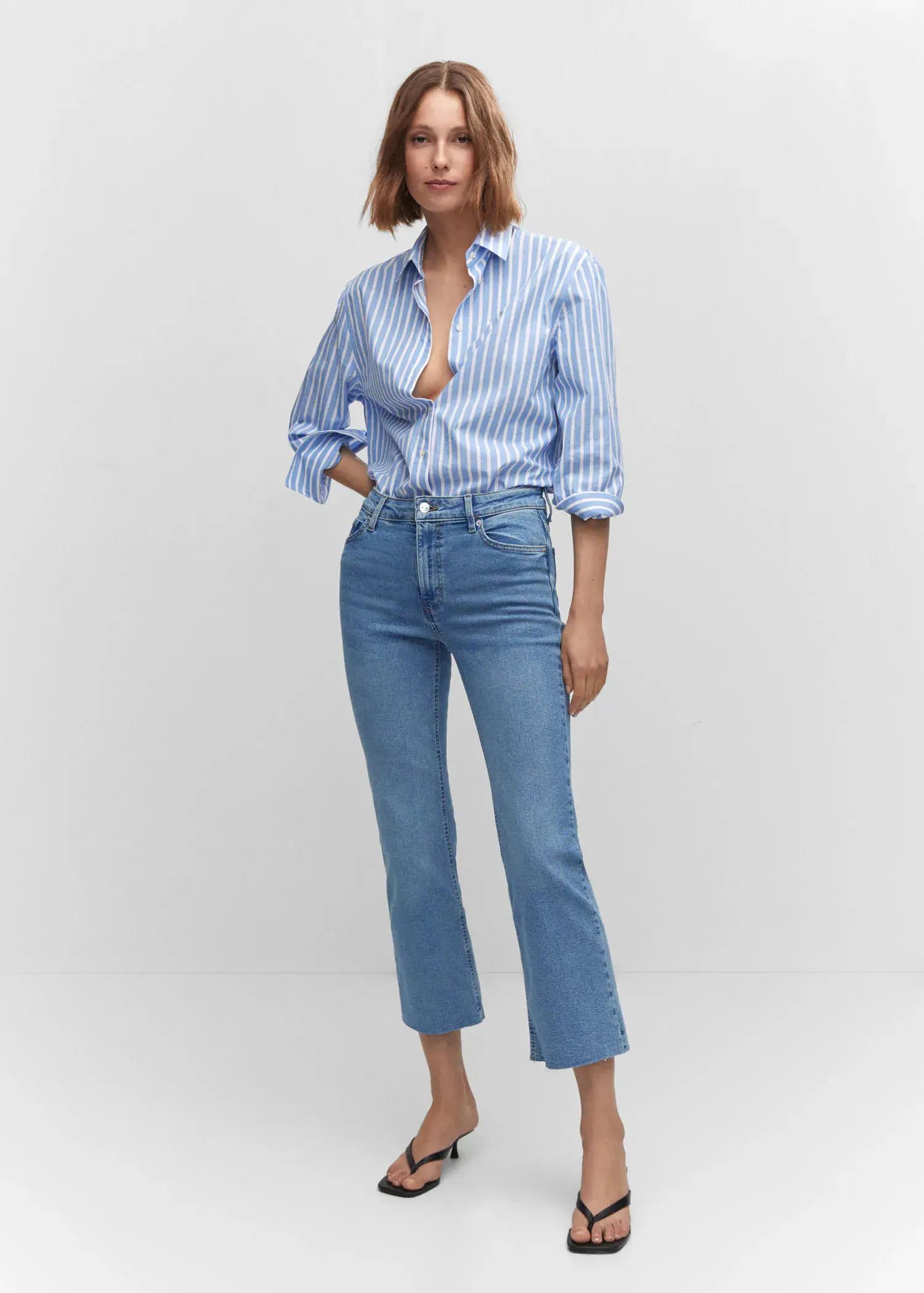 Mango Crop flared jeans. a woman in a striped shirt and jeans. 