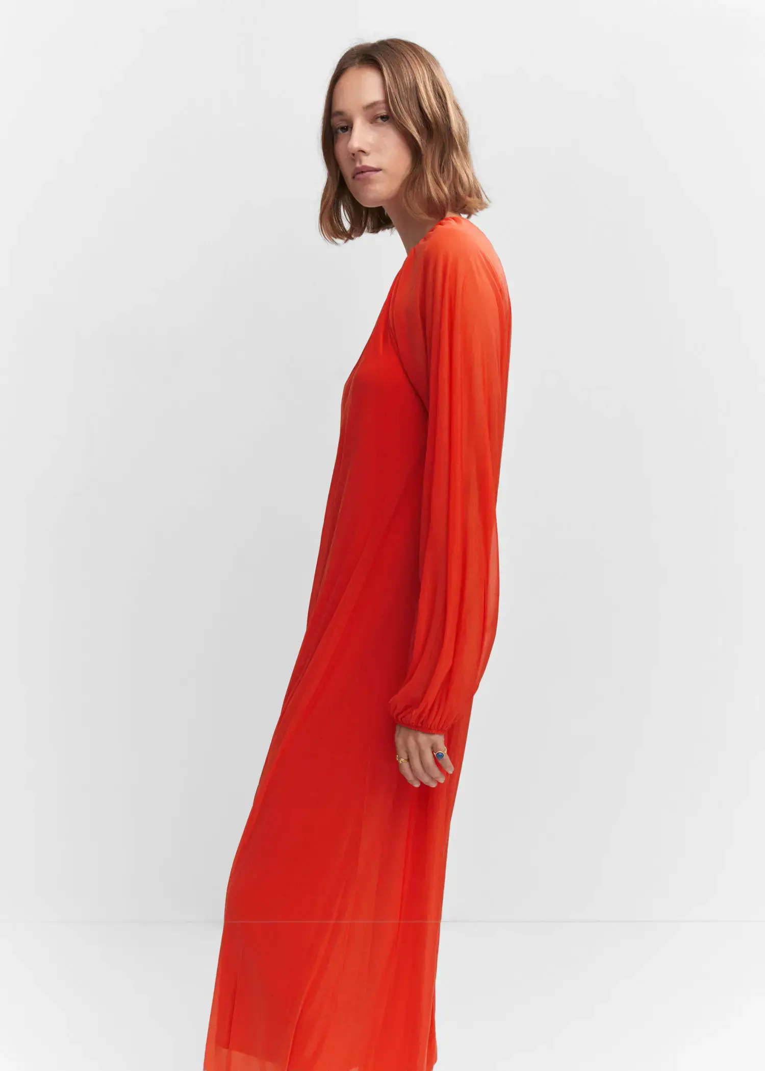 Mango Puffed sleeves dress. a woman wearing a red dress standing next to a white wall. 