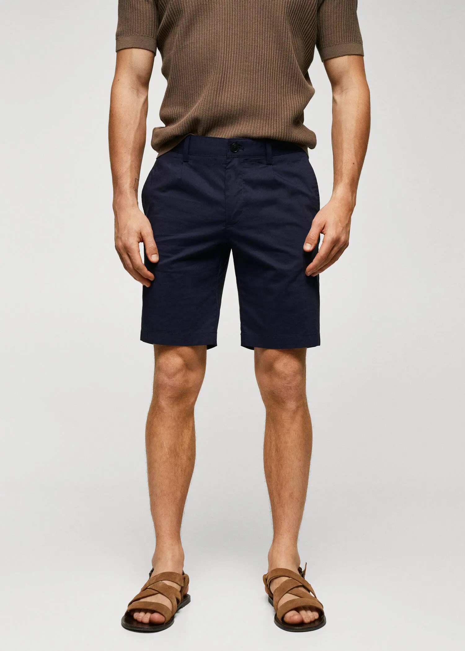 Mango Cotton pleated Bermuda shorts. a man in a brown shirt and a pair of blue shorts. 