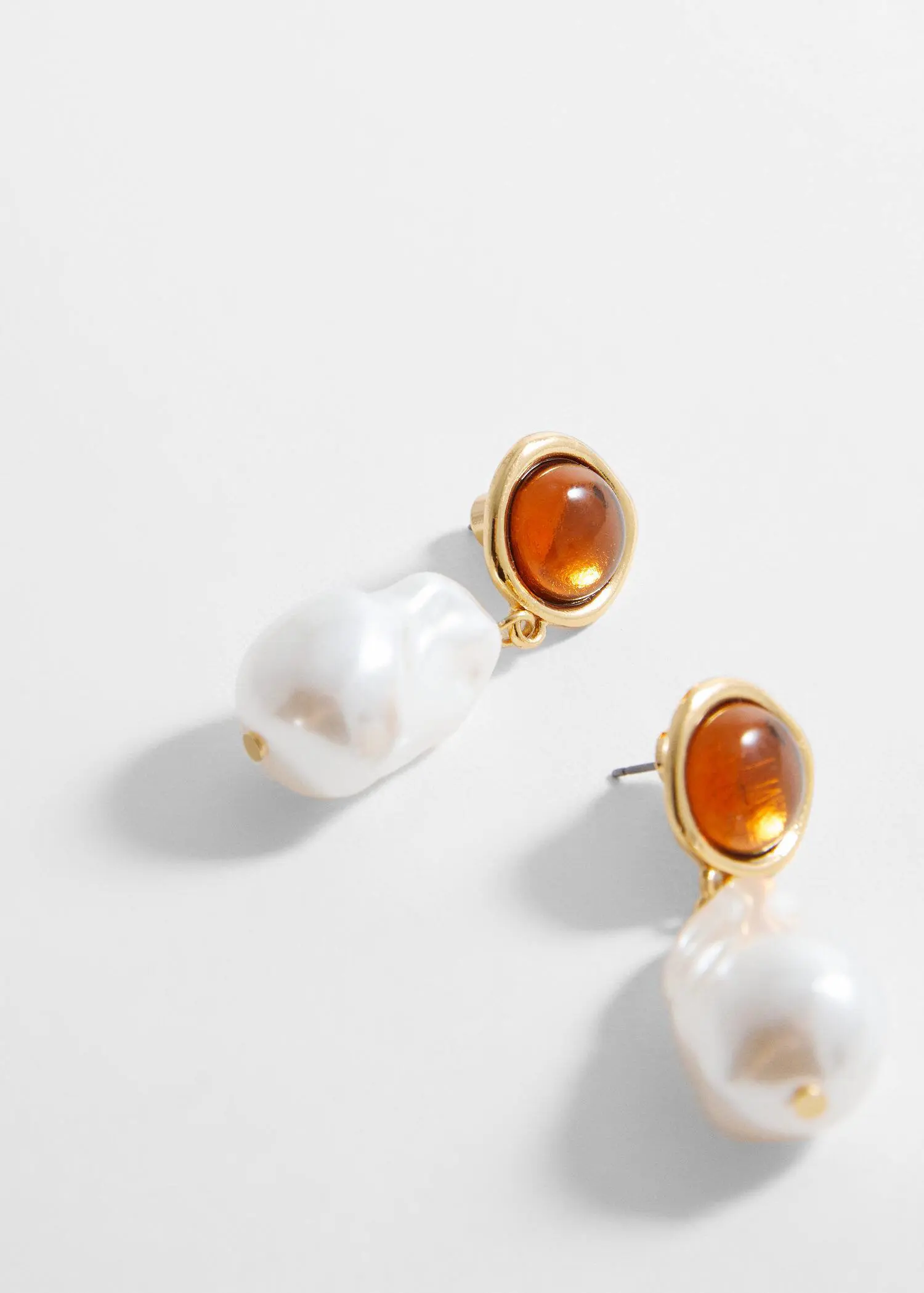 Mango Combined stone earrings. a close up of a pair of earrings on a table 