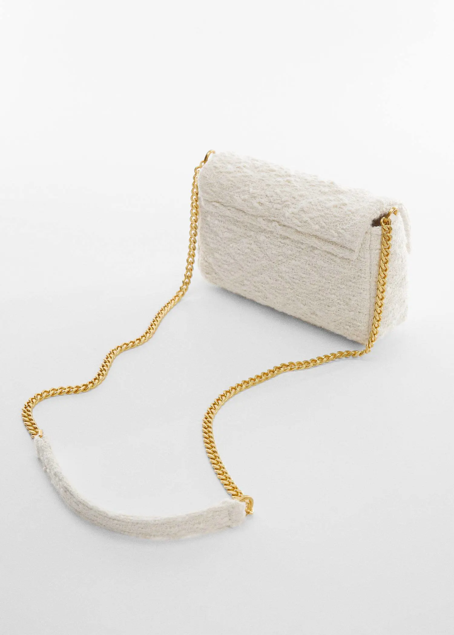 Mango Small textured chain bag. a white purse with a gold chain on a table. 