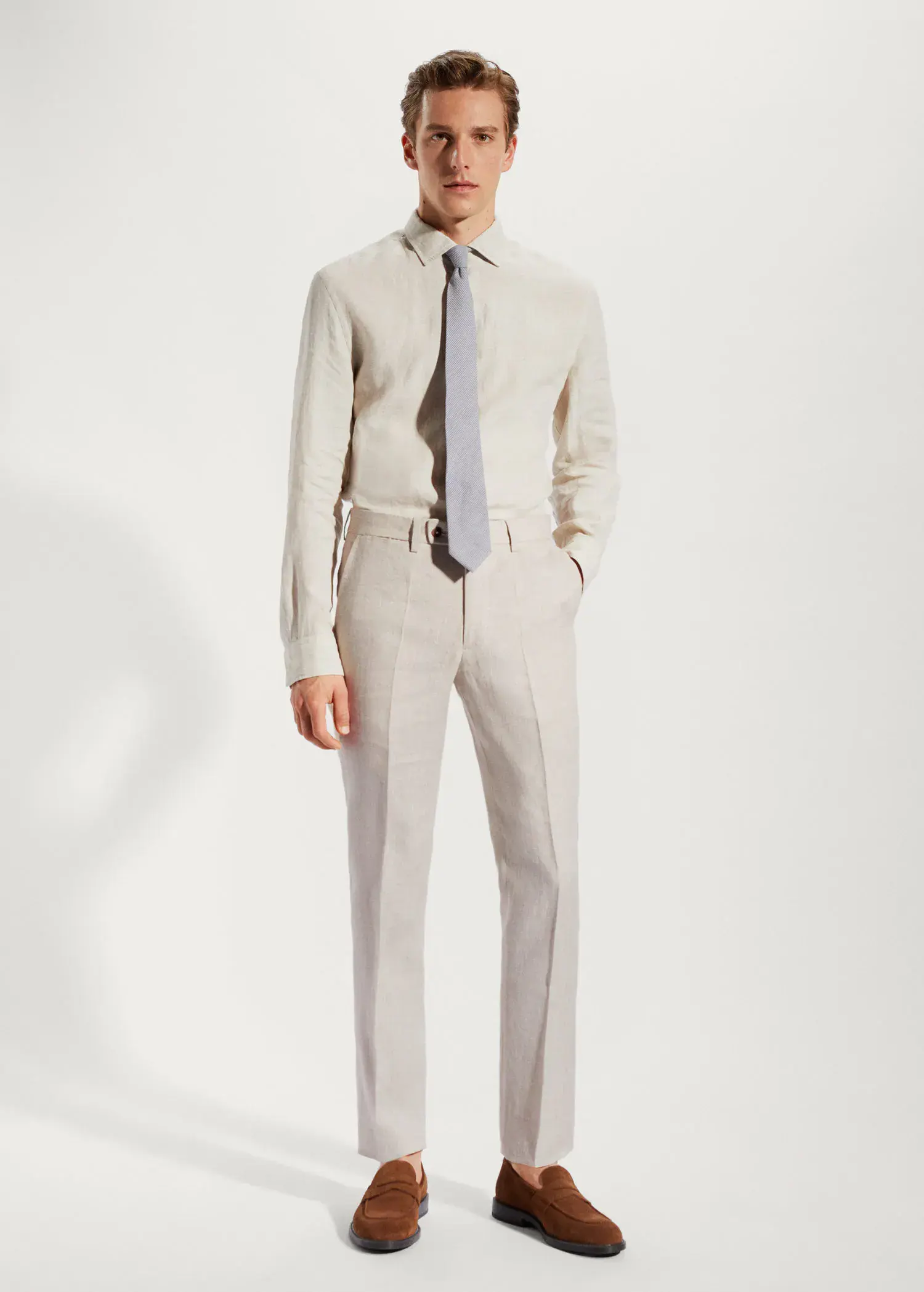 Mango 100% linen suit trousers. a man wearing a suit and tie standing in front of a wall. 