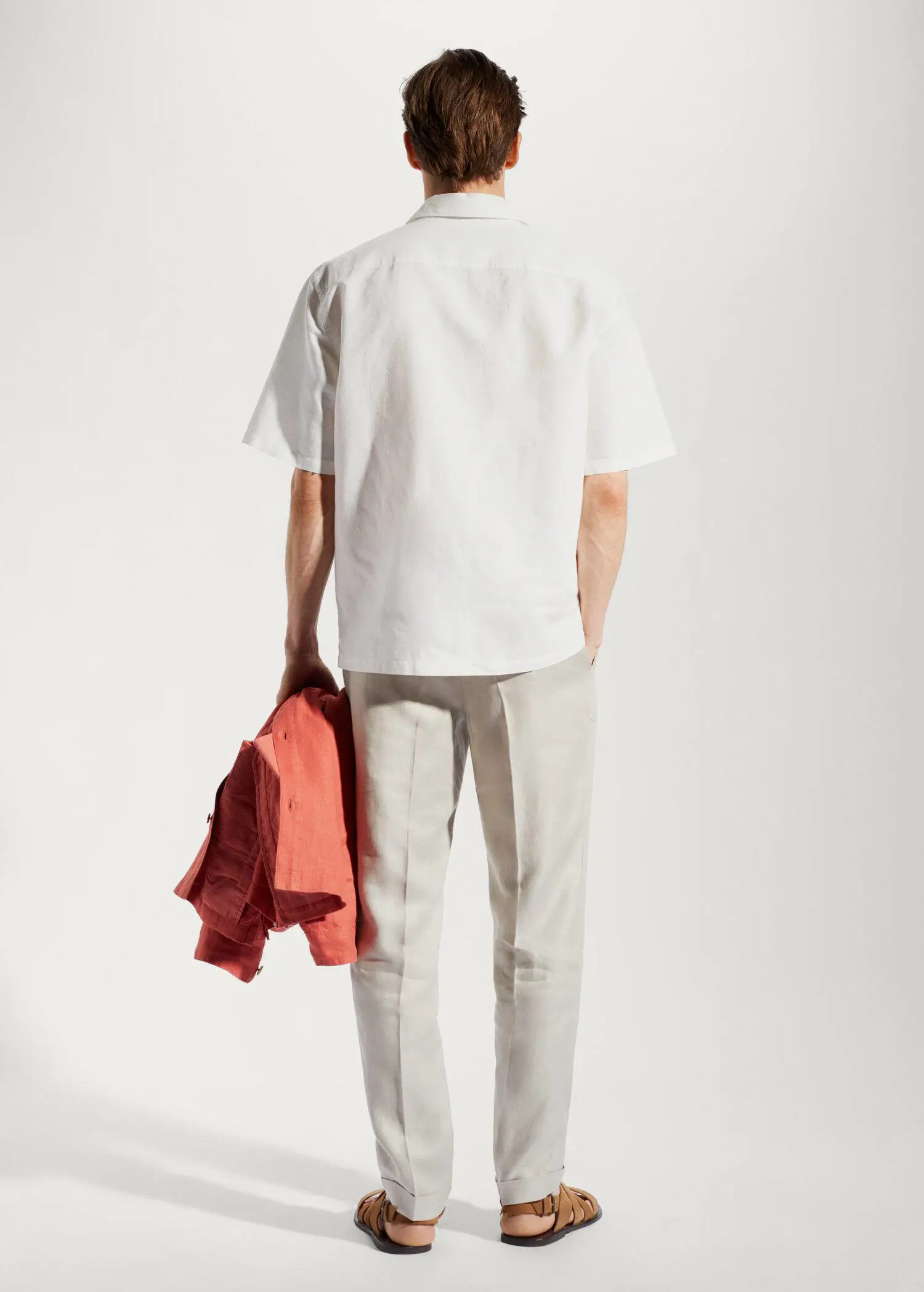 Mango Cotton-linen bowling-collar shirt. a man in a white shirt is holding a jacket. 