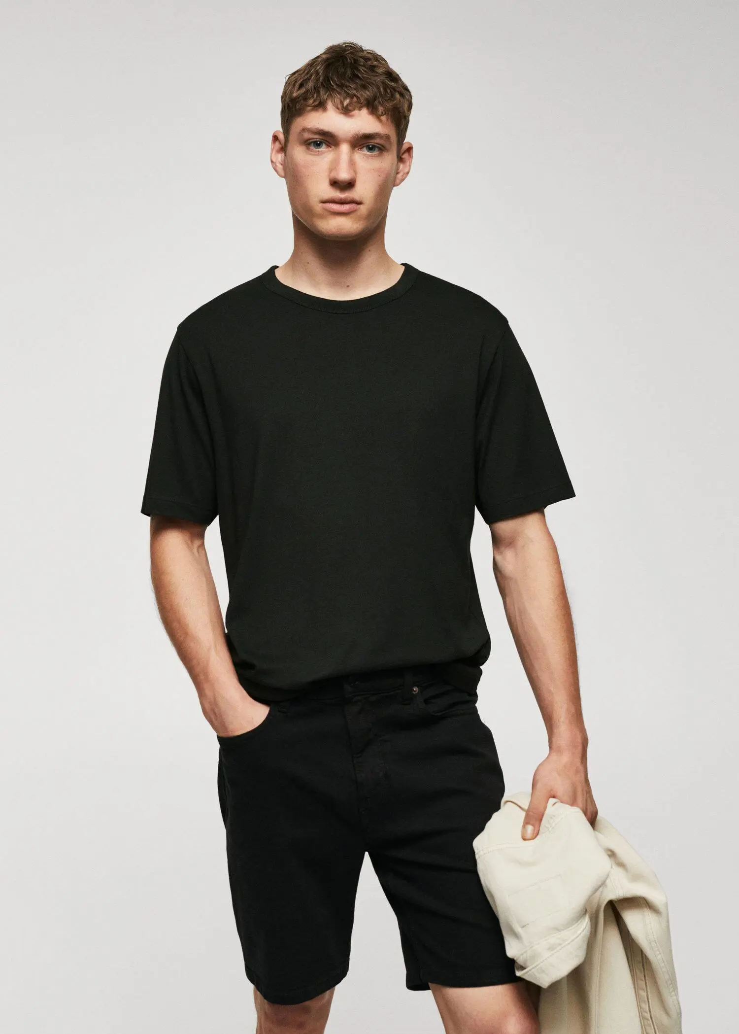 Mango Basic mercerized lightweight shirt. a man in black shirt and black pants holding something. 
