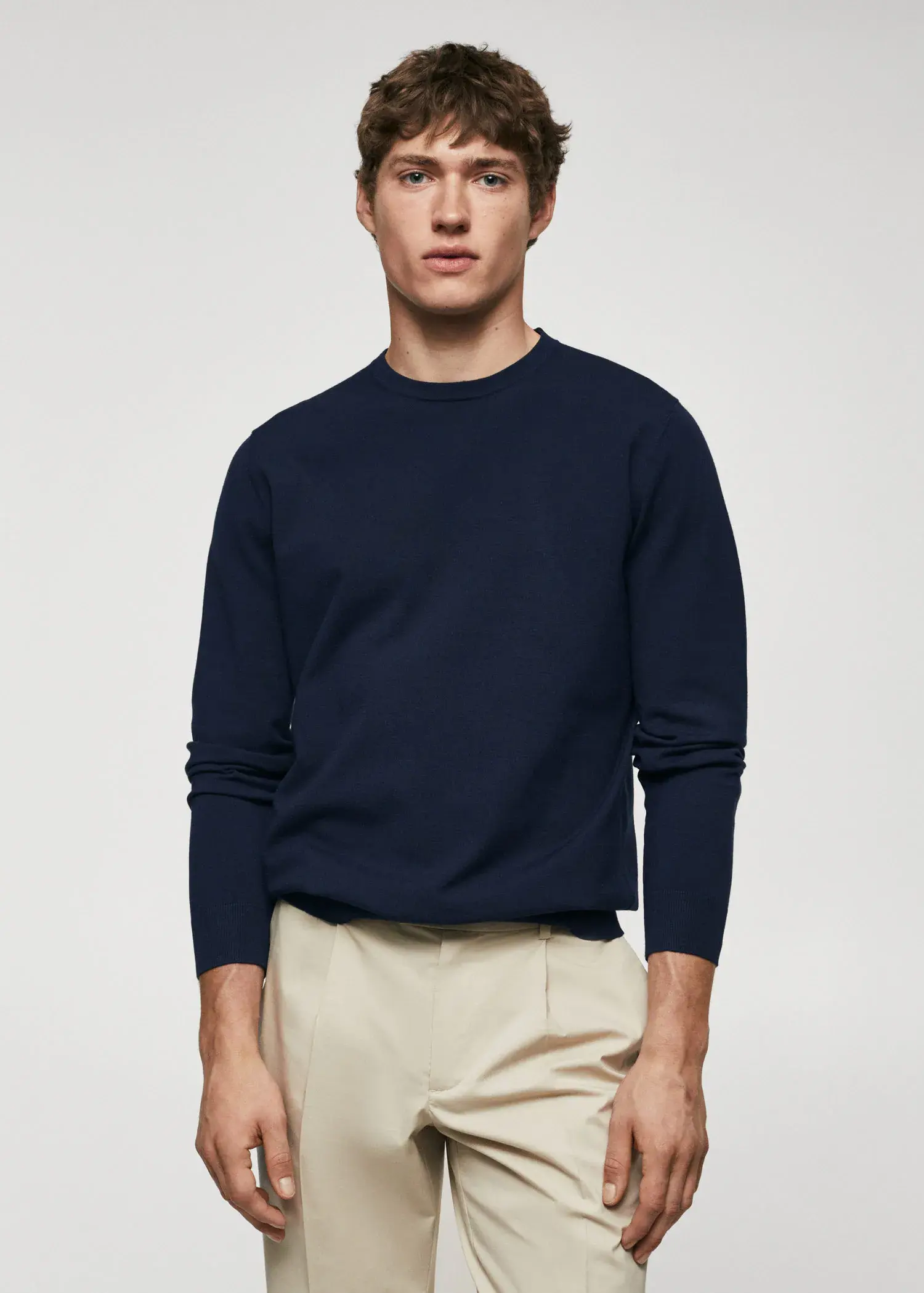Mango Fine-knit sweater. a man wearing a navy blue sweater and beige pants. 