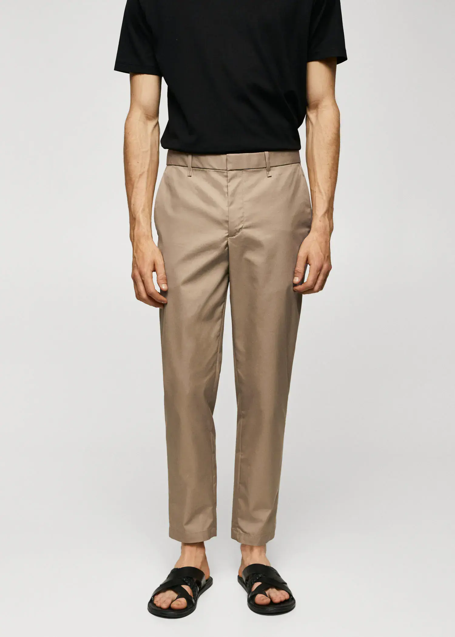 Mango Slim-fit cotton trousers. a man wearing a black shirt and beige pants. 