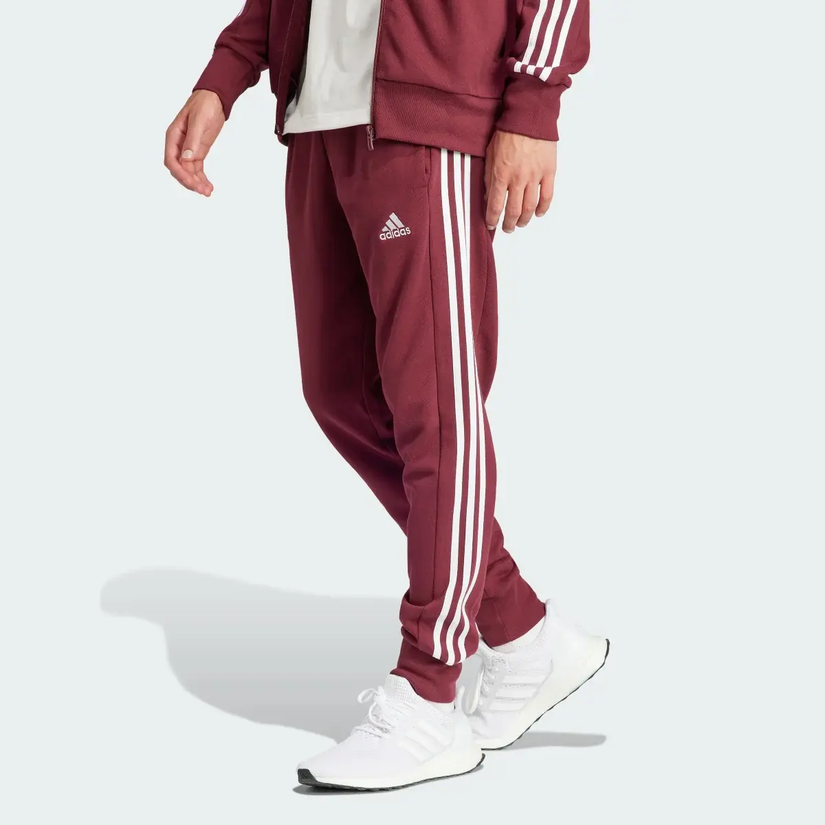 Adidas Pantaloni Essentials French Terry Tapered Cuff 3-Stripes. 1