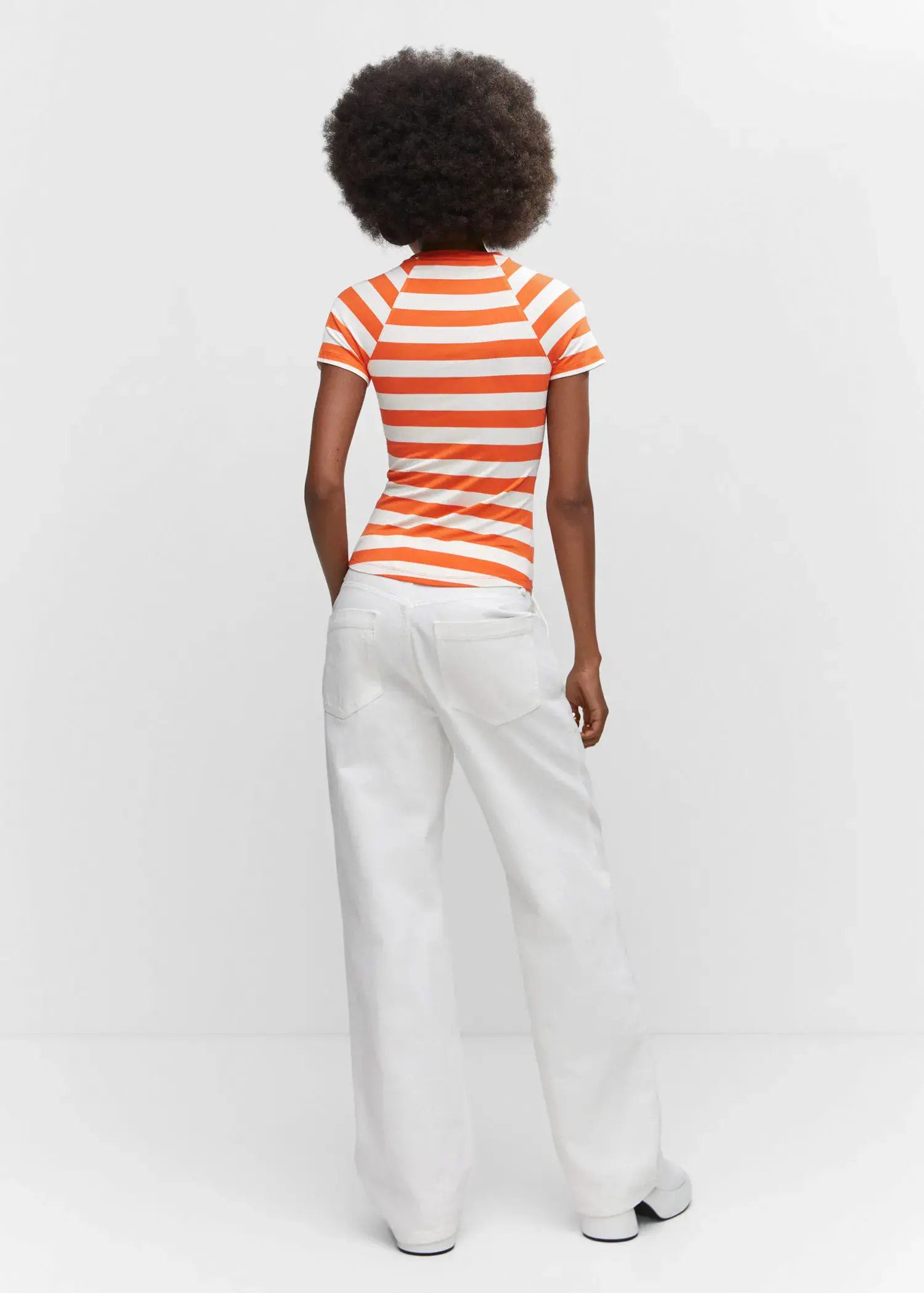 Mango Striped print T-shirt. a woman wearing a striped shirt and white pants. 