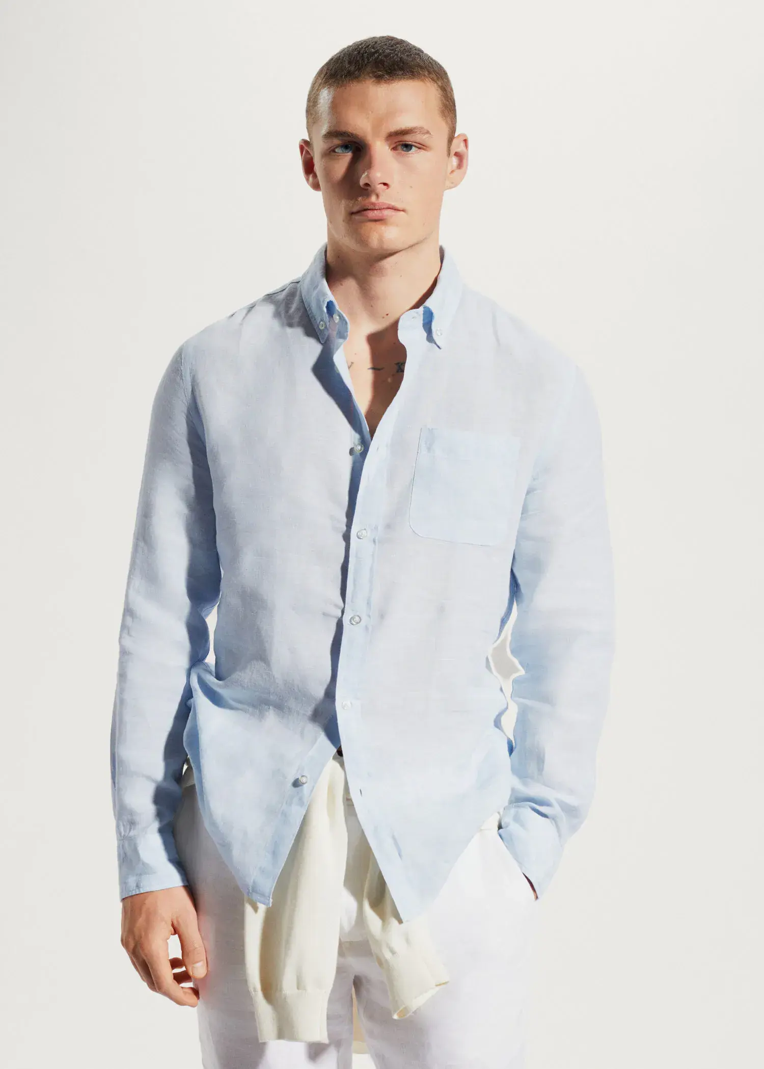 Mango 100% linen slim-fit shirt. a man wearing a light blue shirt and white pants. 