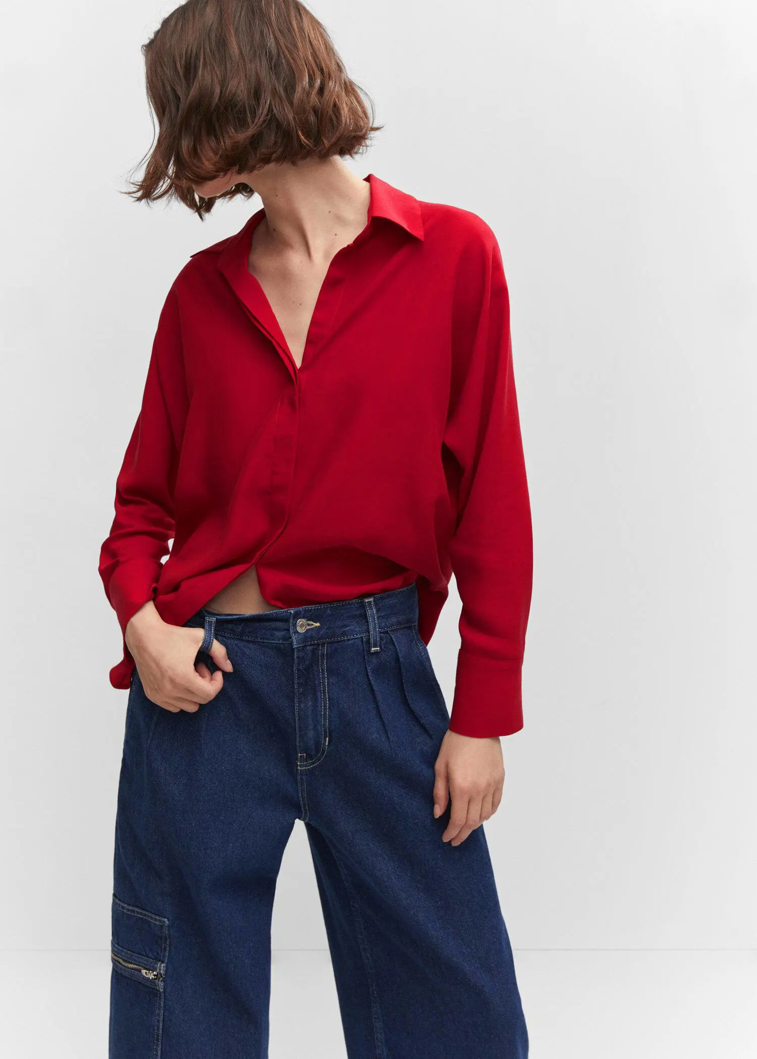 Mango Lyocell fluid shirt. a woman in a red shirt is holding her pants. 