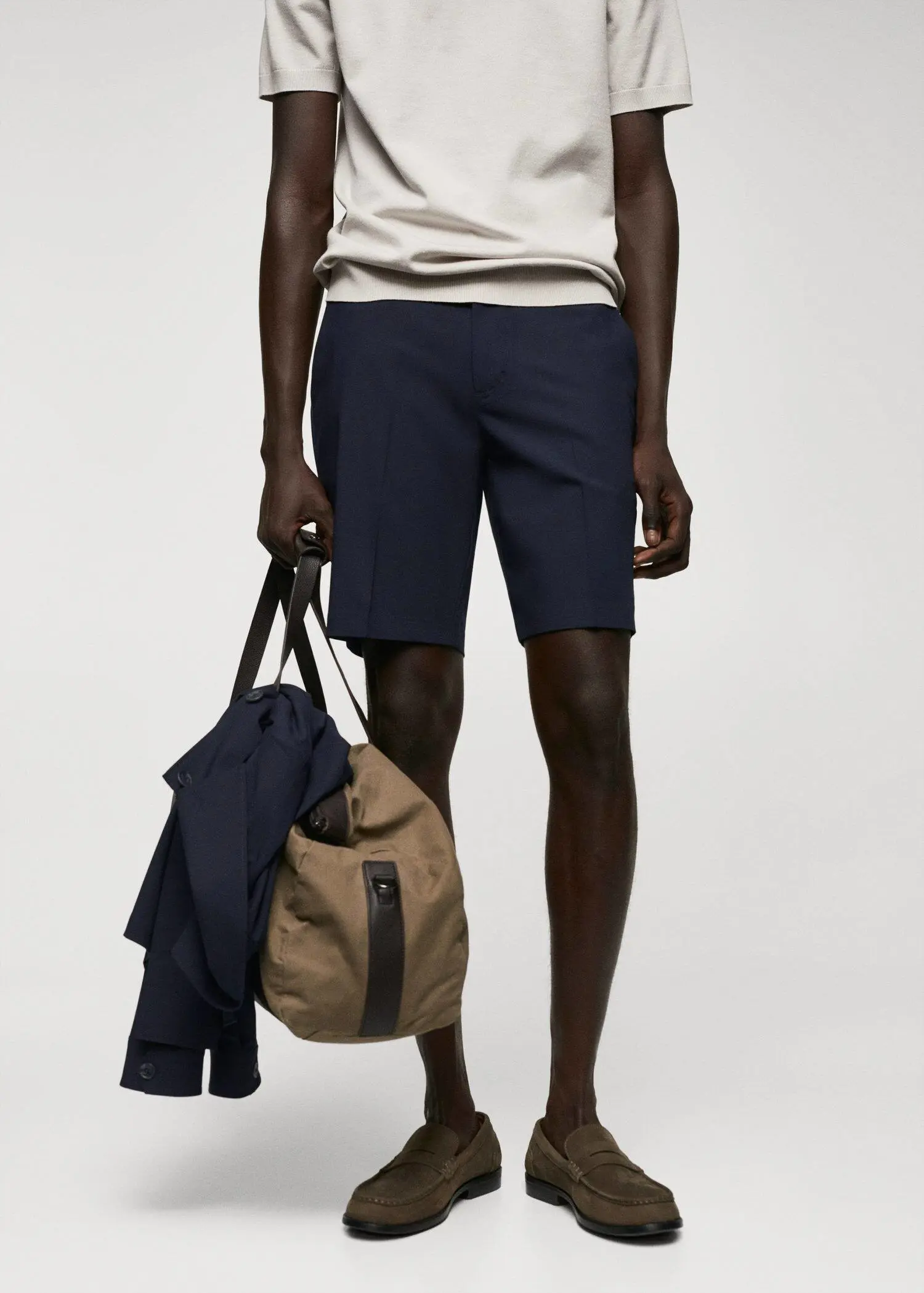 Mango Slim-fit bermuda shorts with adjustable waist. a man holding a bag in front of him. 