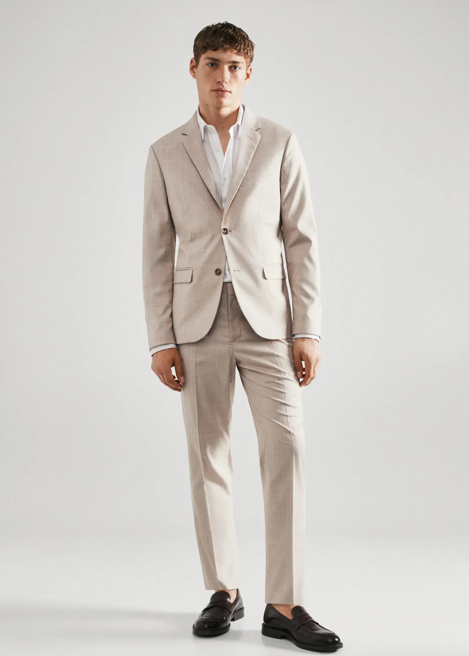 Mango Super slim-fit check suit jacket. a man in a suit standing in front of a white wall. 