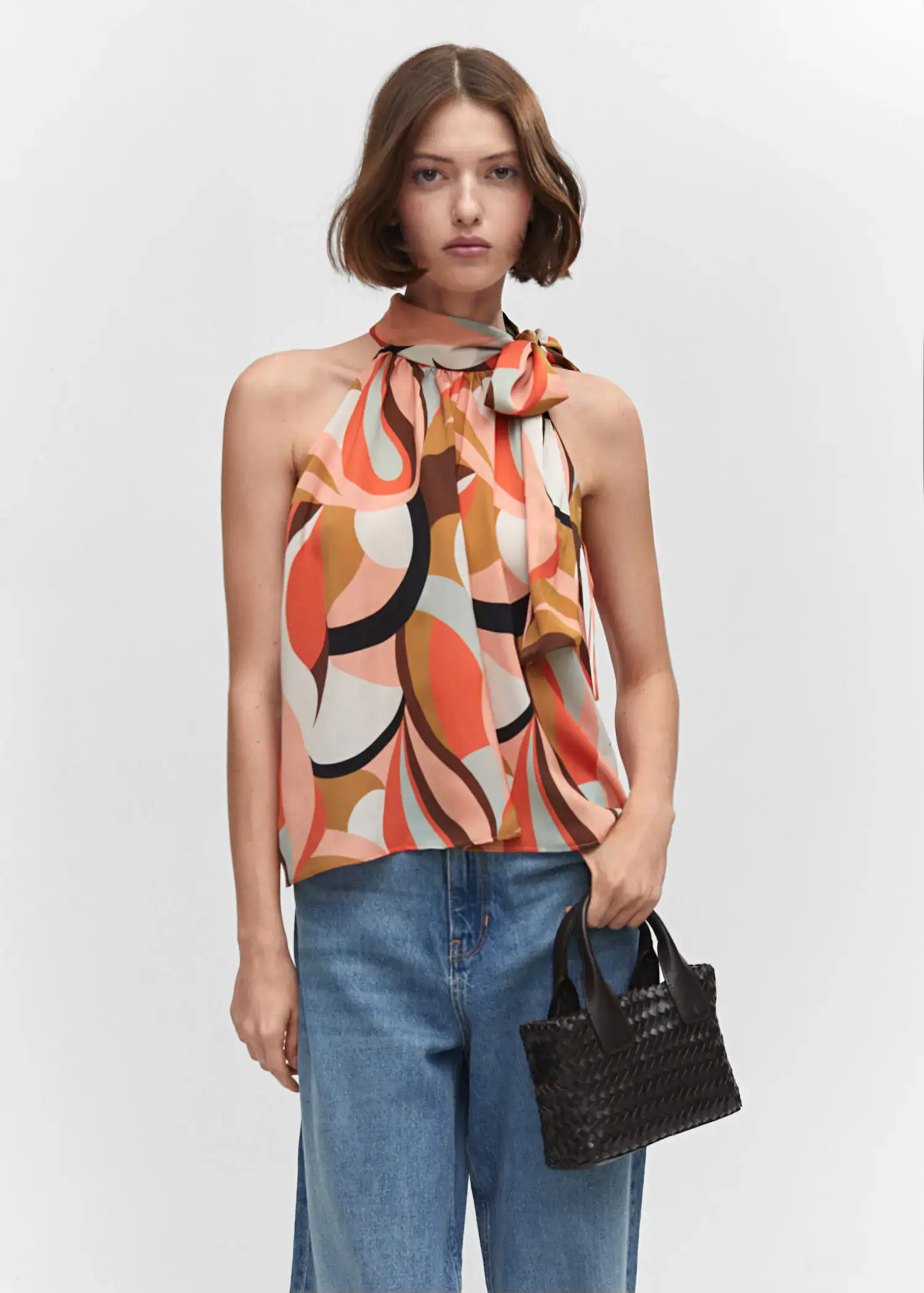 Mango Halter neck blouse with bow. a woman wearing a colorful top holding a purse. 
