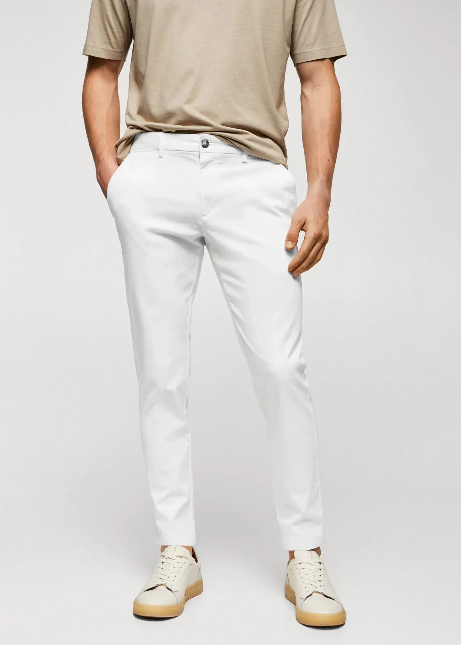 Mango Cotton tapered crop pants. a man wearing white pants and a tan shirt. 