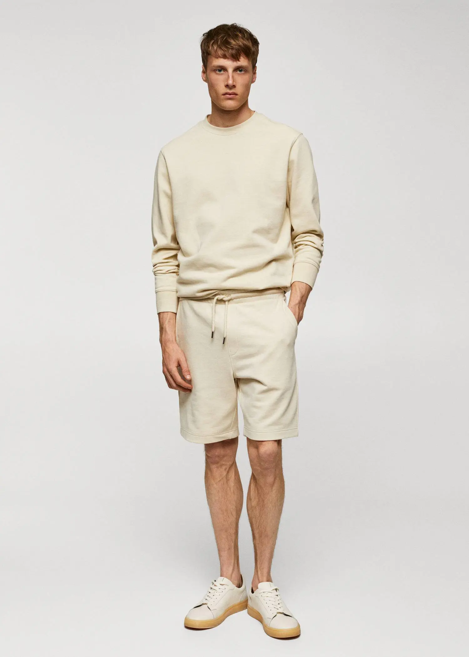 Mango Jogger cotton Bermuda shorts. a man in a beige sweatshirt and shorts. 