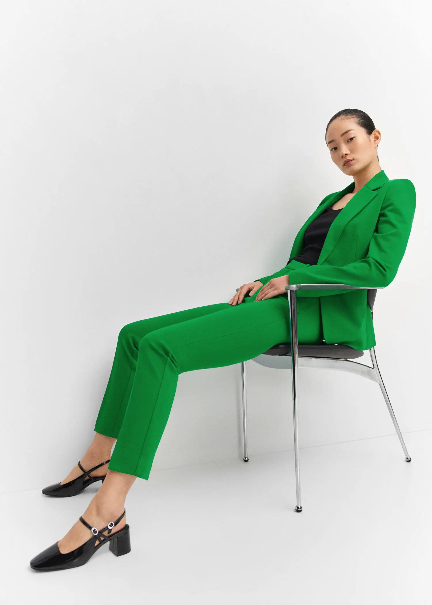 Mango Rome-knit straight pants. a woman sitting on a chair wearing a green suit. 