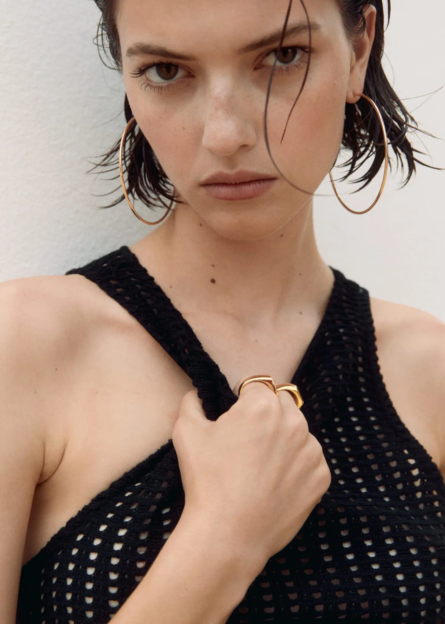 Mango Maxi hoop earrings. a close up of a person wearing a black top 