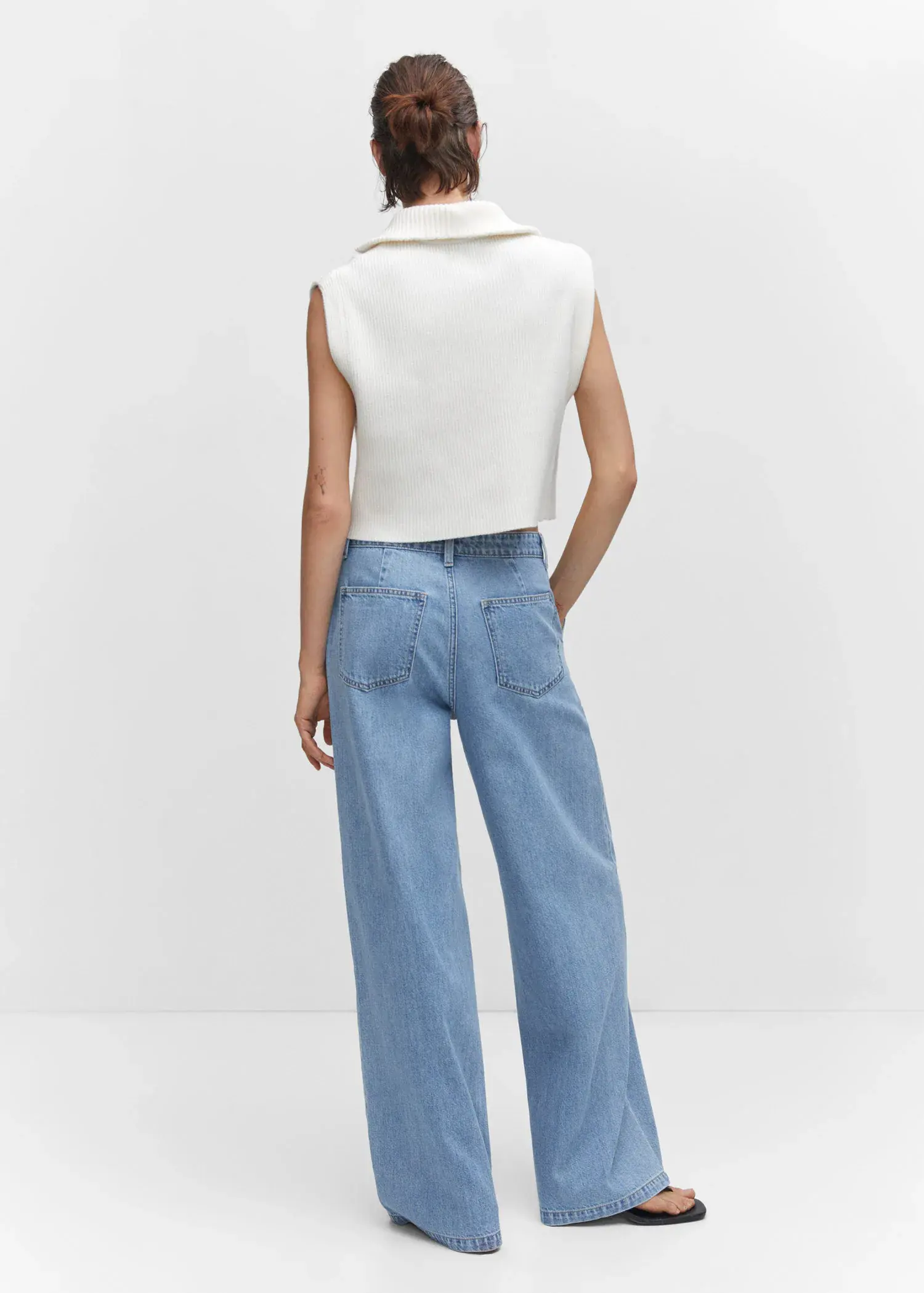 Mango Wide-leg pleated jeans. a woman wearing a white top and blue jeans. 
