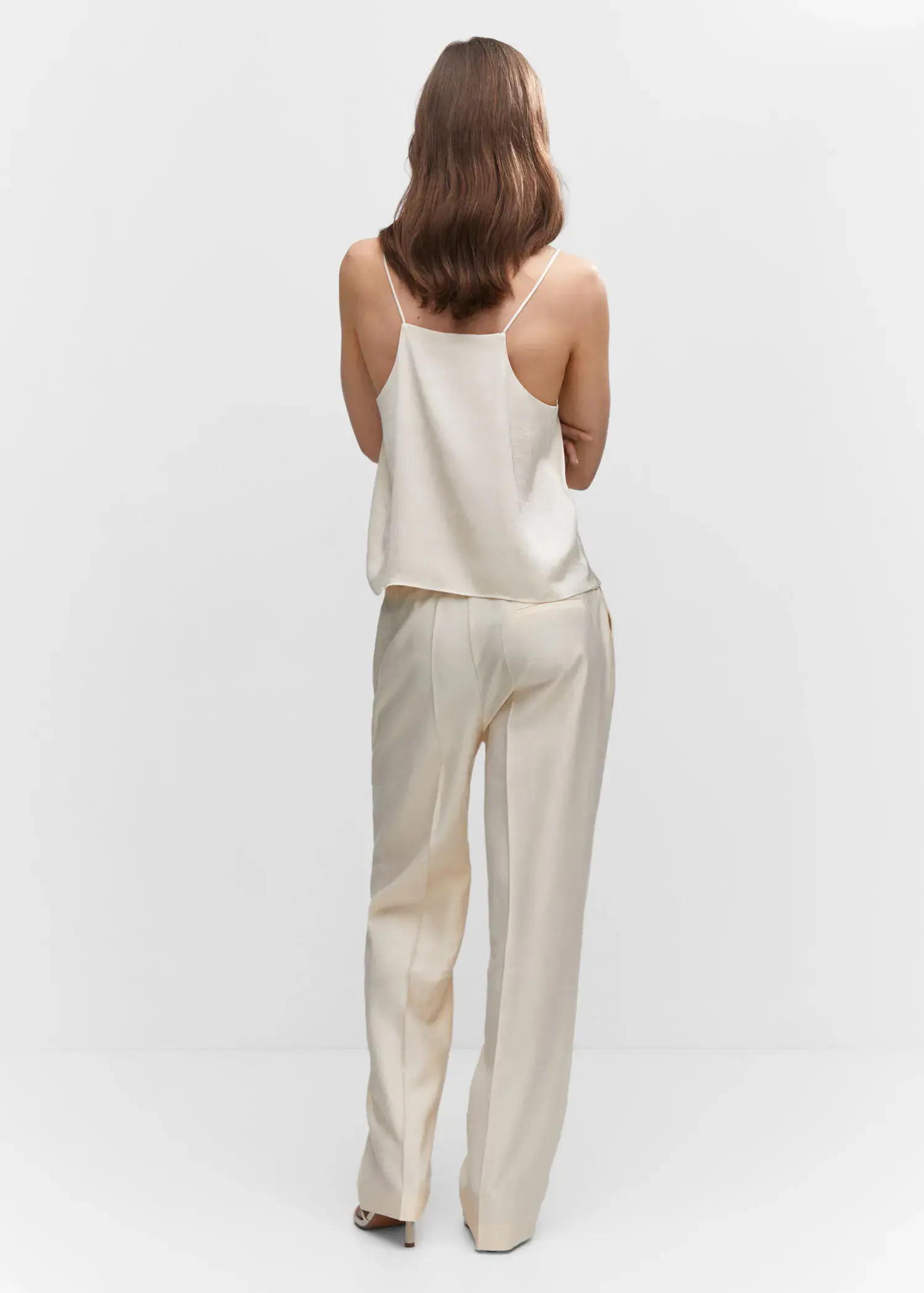 Mango Satin top with straps. a woman wearing a white top and white pants. 