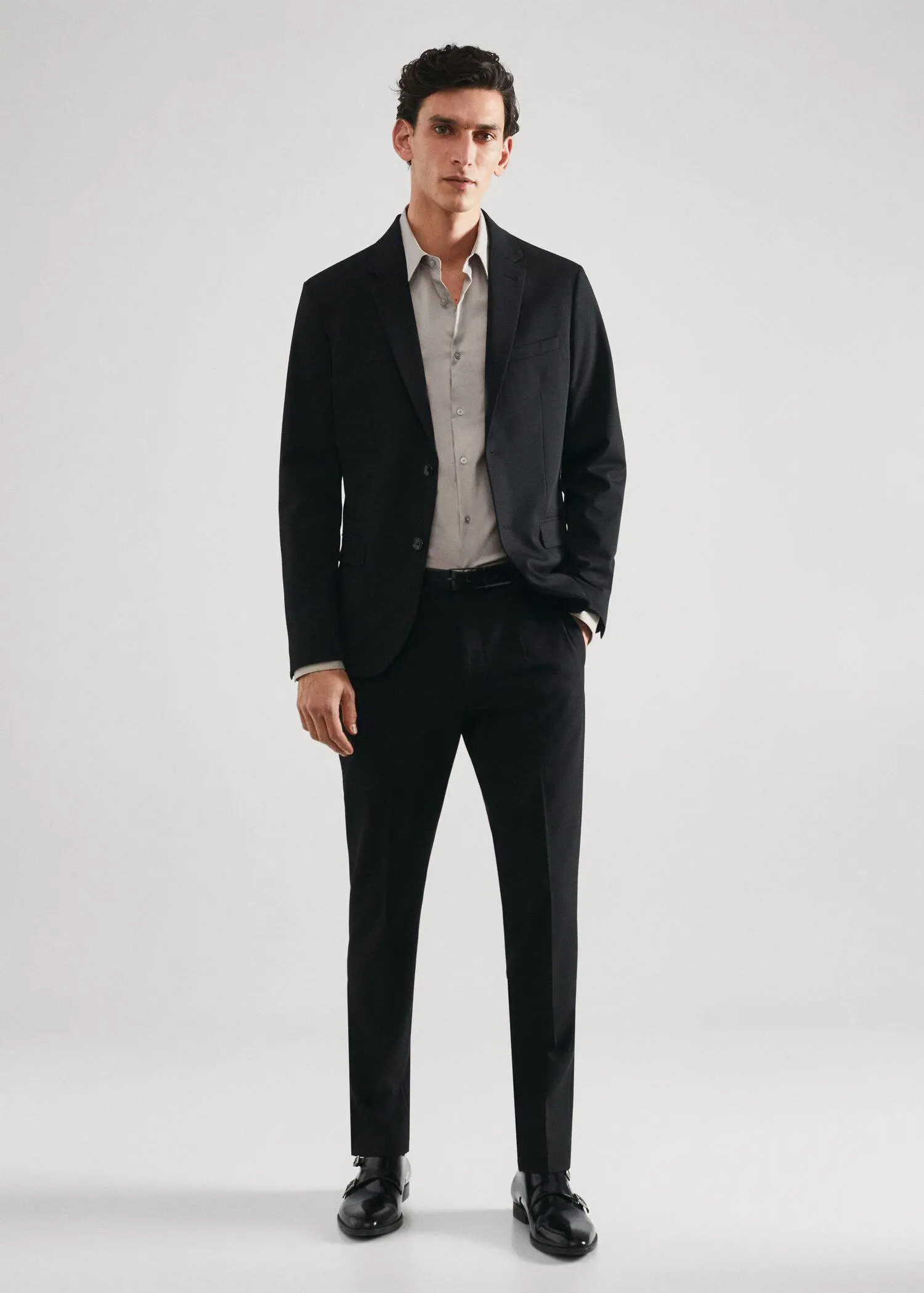Mango Super slim-fit poplin suit shirt. a man in a suit standing with his hands in his pockets. 