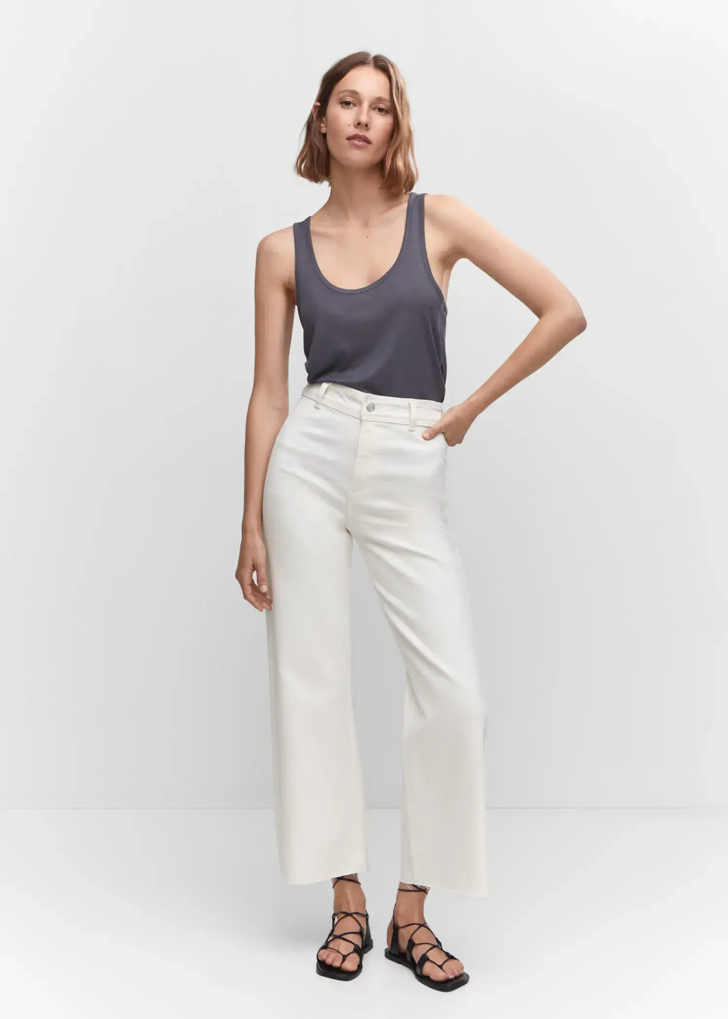 Mango Jeans culotte high waist. a woman standing in front of a white wall. 