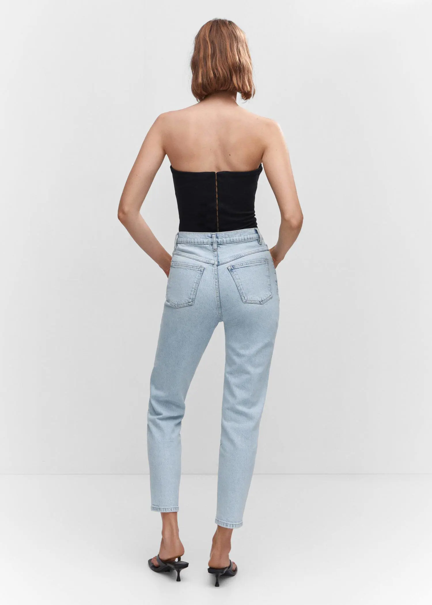 Mango Mom comfort high-rise jeans. a woman is standing in front of a wall. 