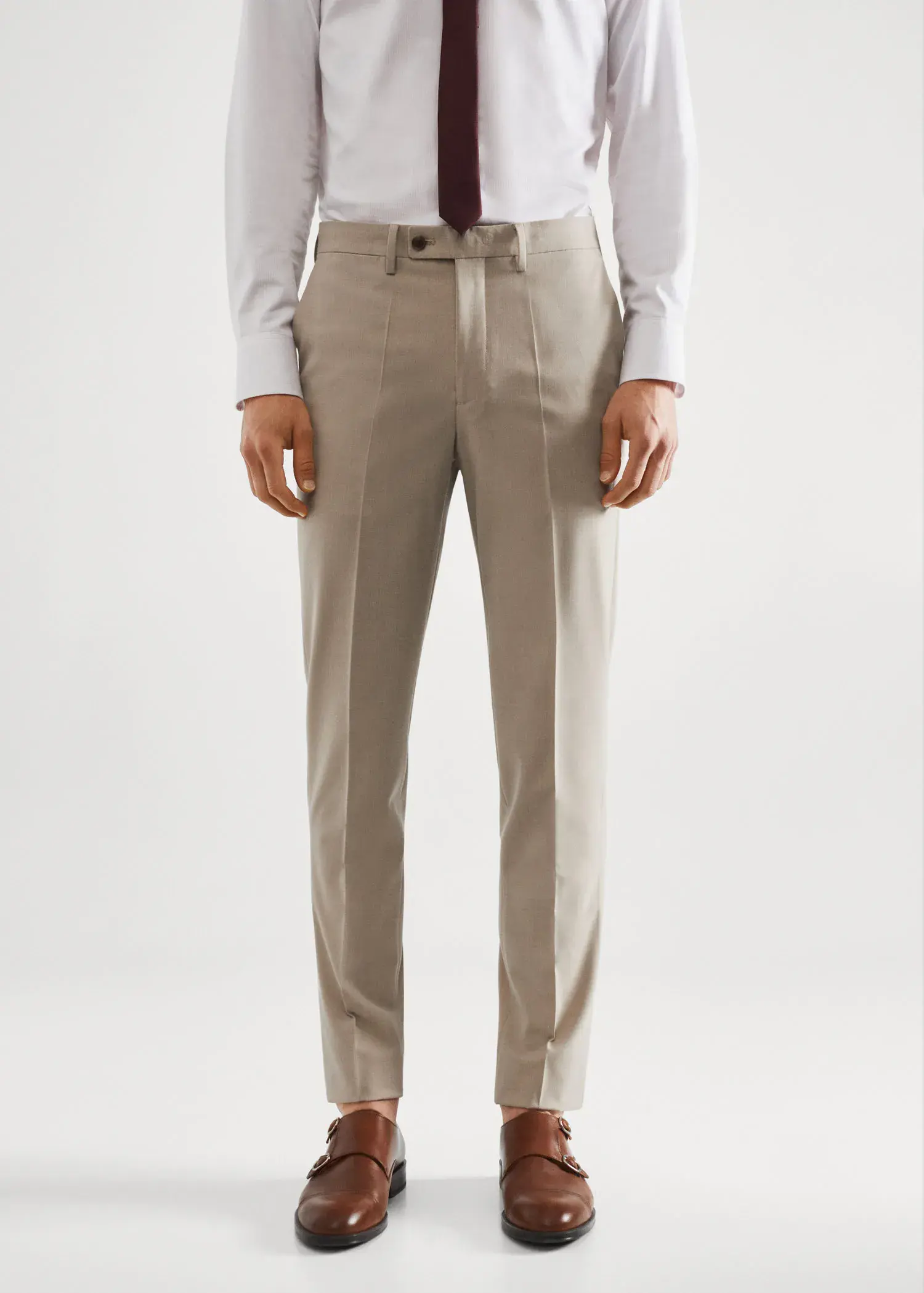 Mango Stretch fabric slim-fit suit pants. a man wearing a suit and tie standing in front of a white wall. 