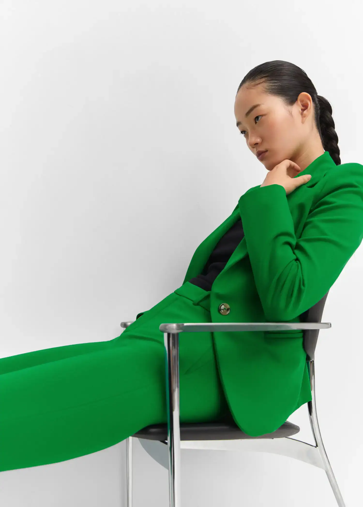 Mango Fitted jacket with blunt stitching. a woman sitting in a chair wearing a green suit. 