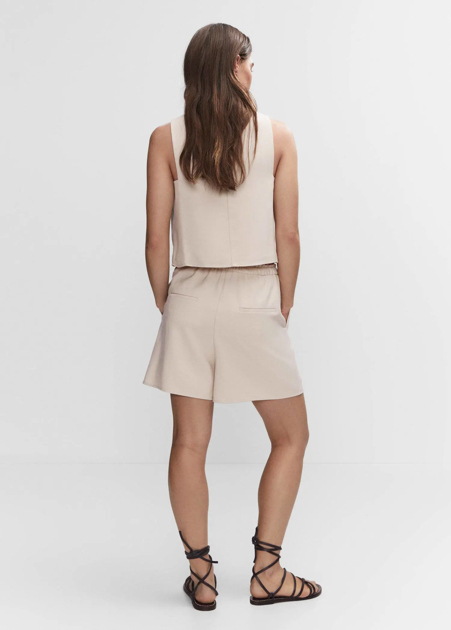 Mango Elastic waist shorts. a woman in a beige outfit standing in front of a white wall. 