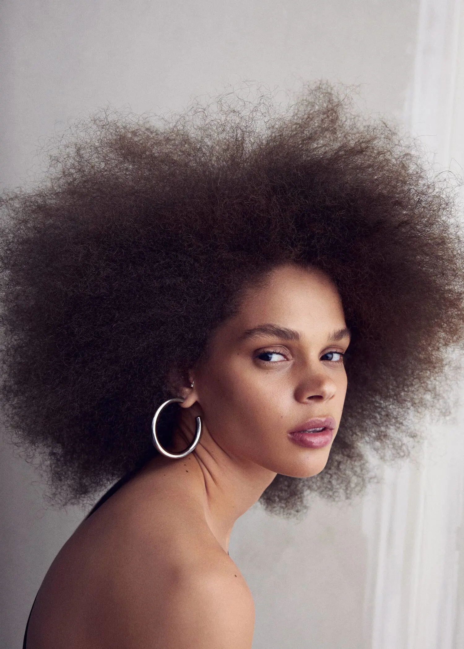 Mango Hoop earrings. a beautiful woman with a large afro hair style. 