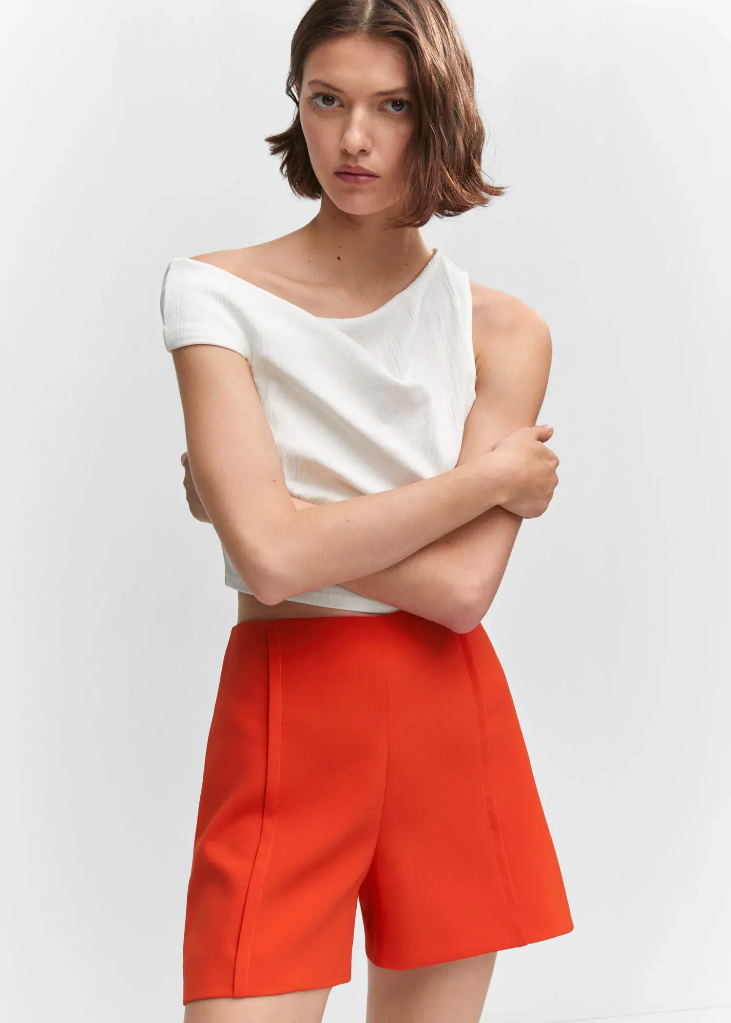 Mango High-waist straight shorts. a woman wearing a white top and orange shorts. 