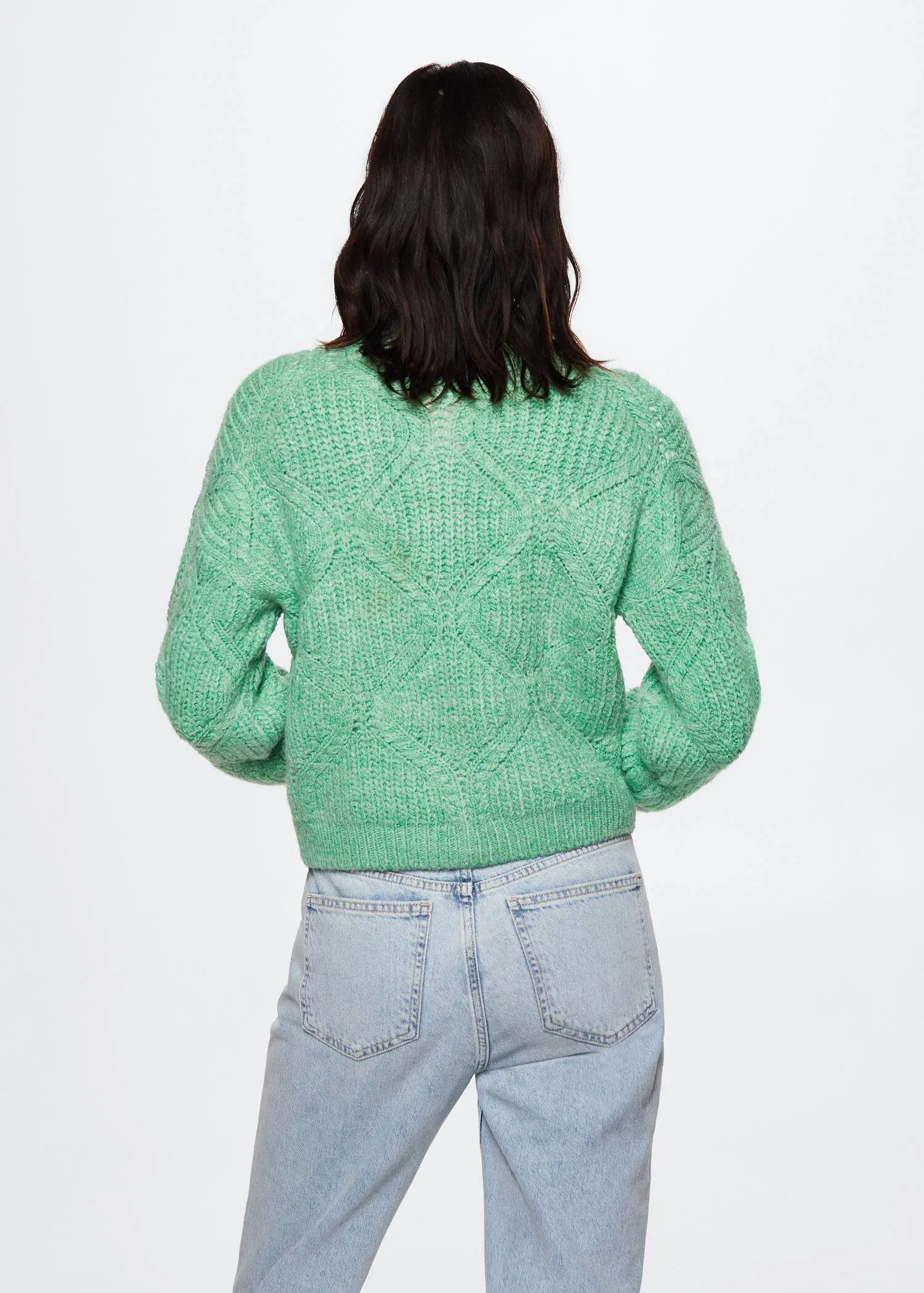 Mango Cable-knit cardigan. a person wearing a green sweater and jeans. 