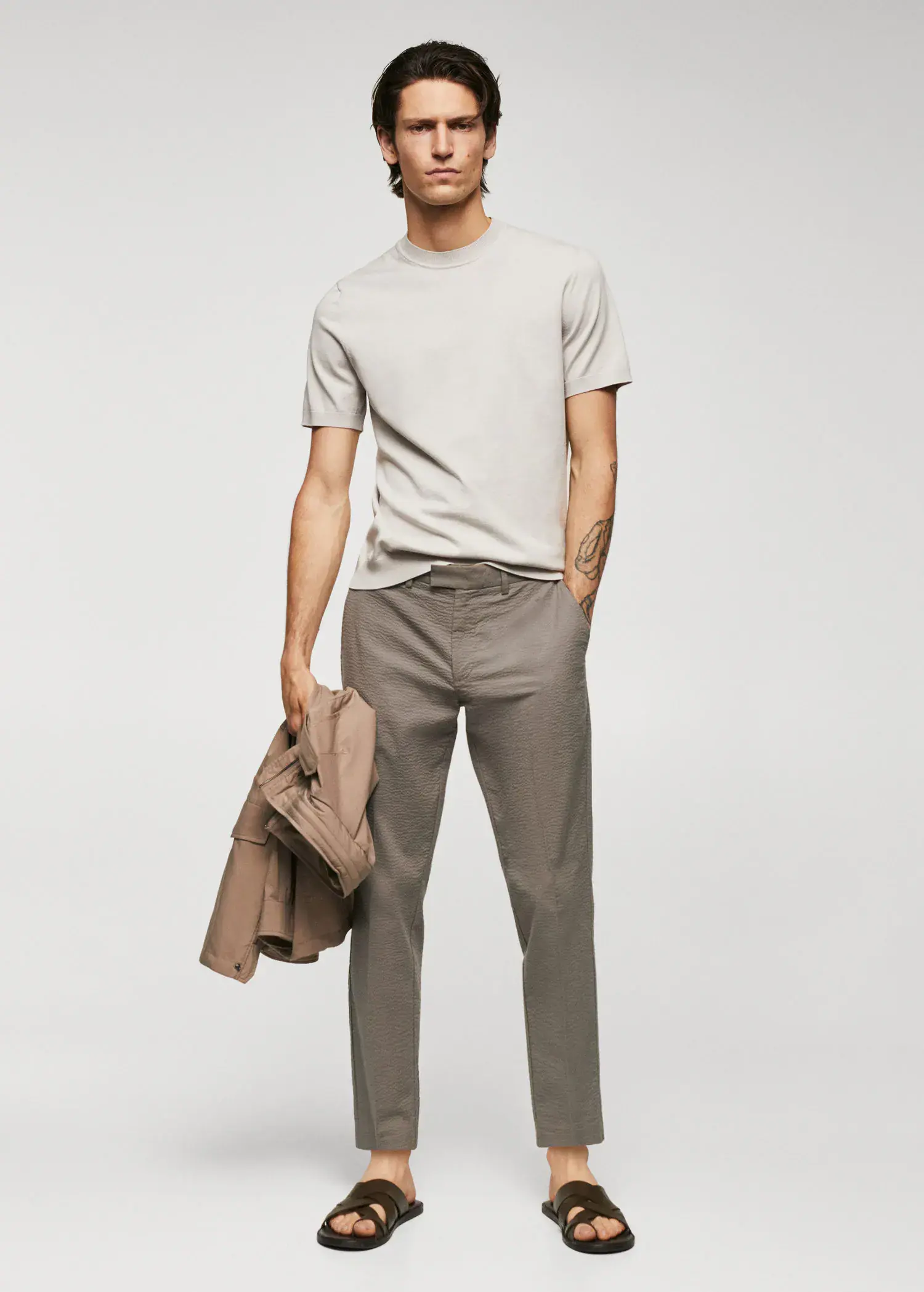Mango Slim-fit seersucker stretch trousers. a man in a white shirt is holding a jacket. 