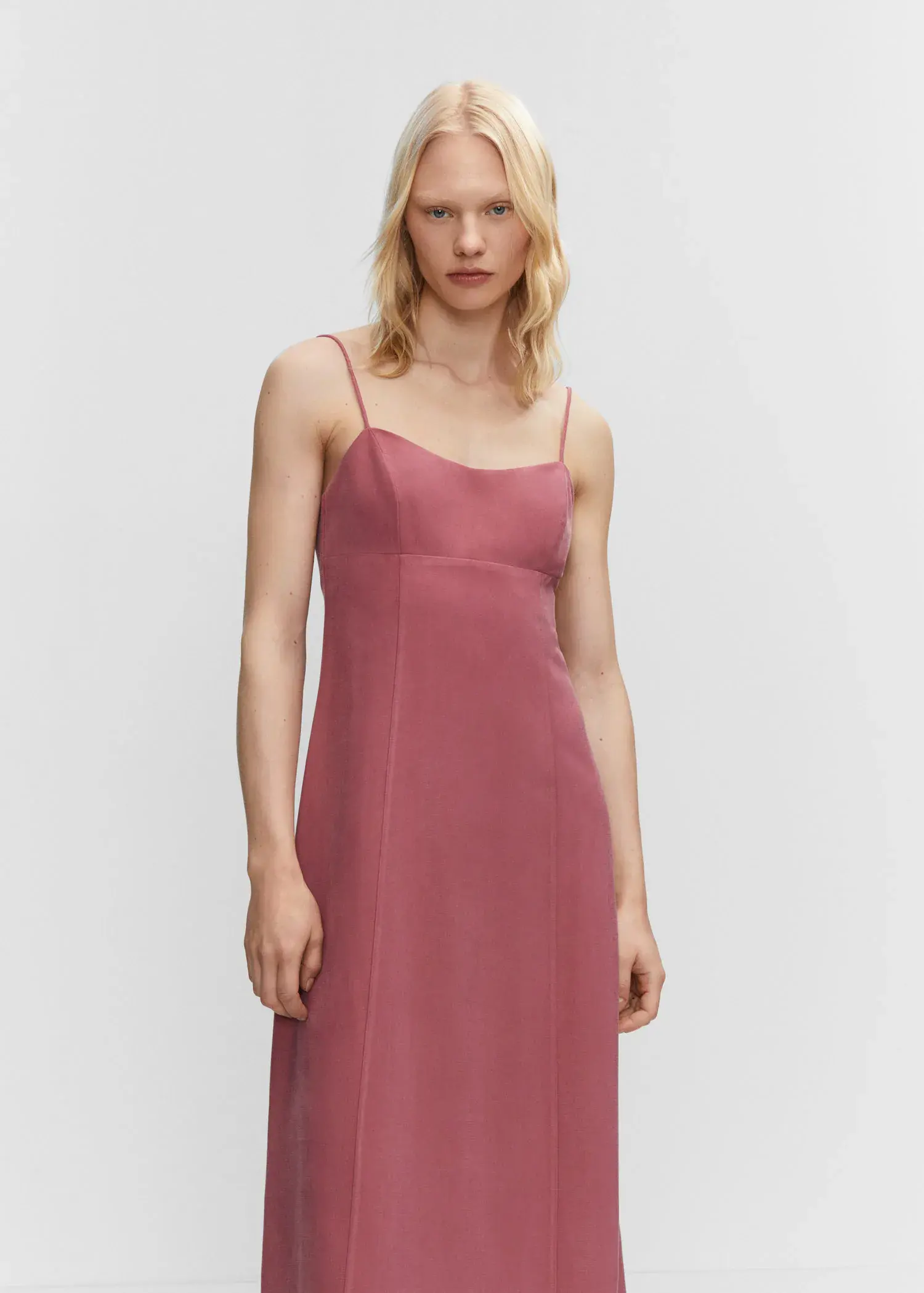 Mango Low-cut midi-dress. a woman wearing a pink dress standing in front of a white wall. 