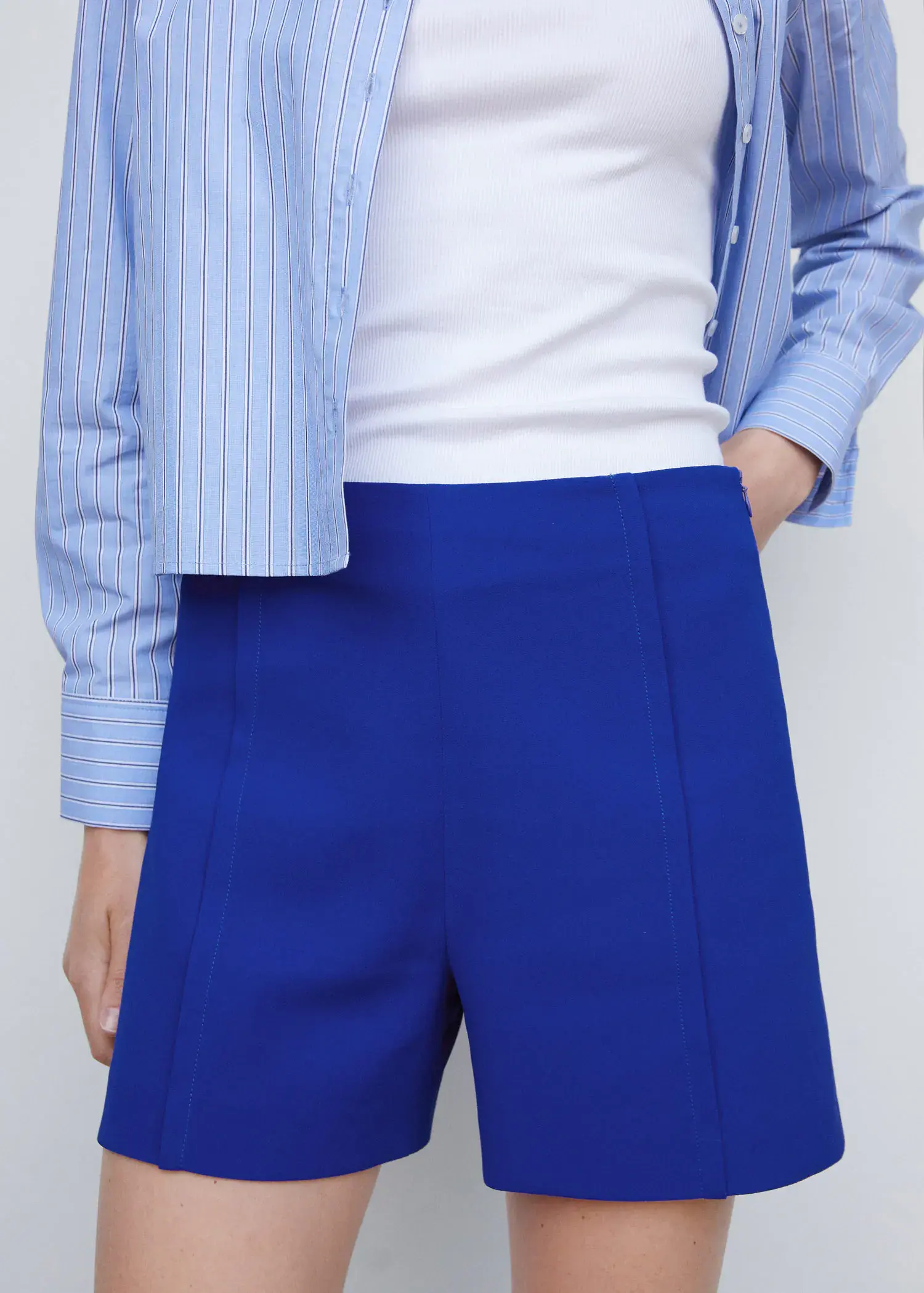 Mango High-waist straight shorts. a person wearing blue pants and a white shirt. 