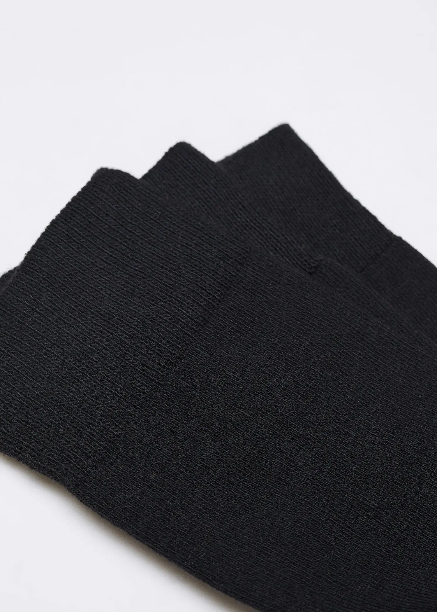 Mango Pack of 3 cotton socks. a close-up view of a black cloth on a table. 