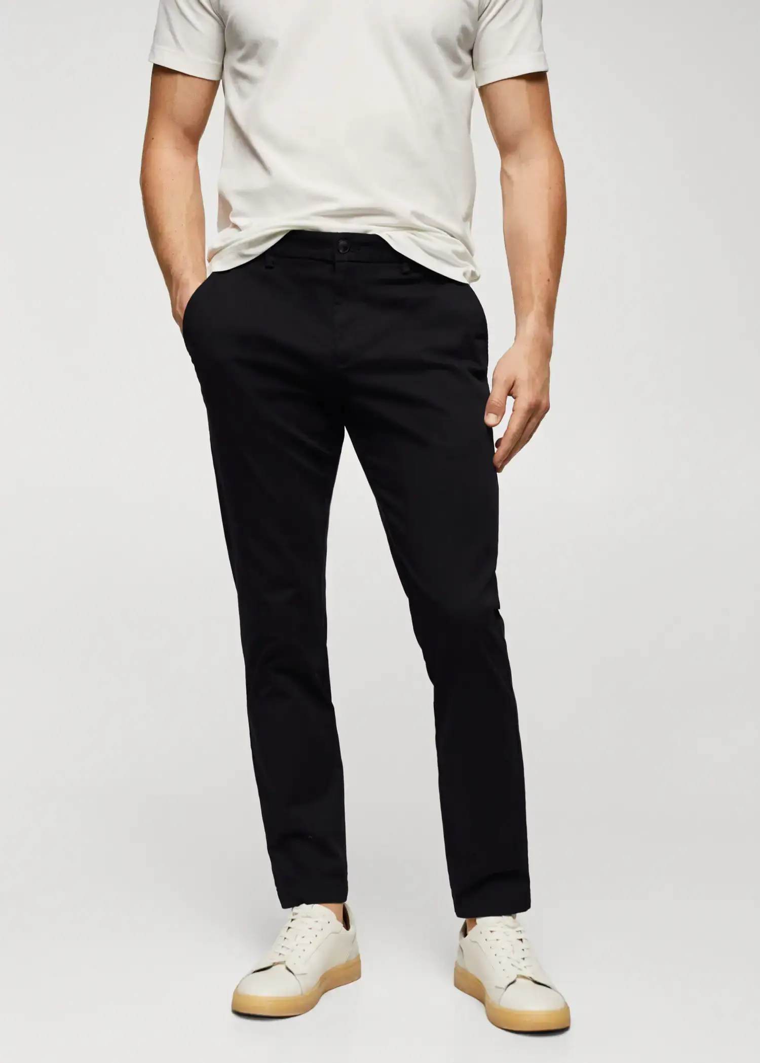 Mango Cotton tapered crop pants. a man is standing with his hands in his pockets. 