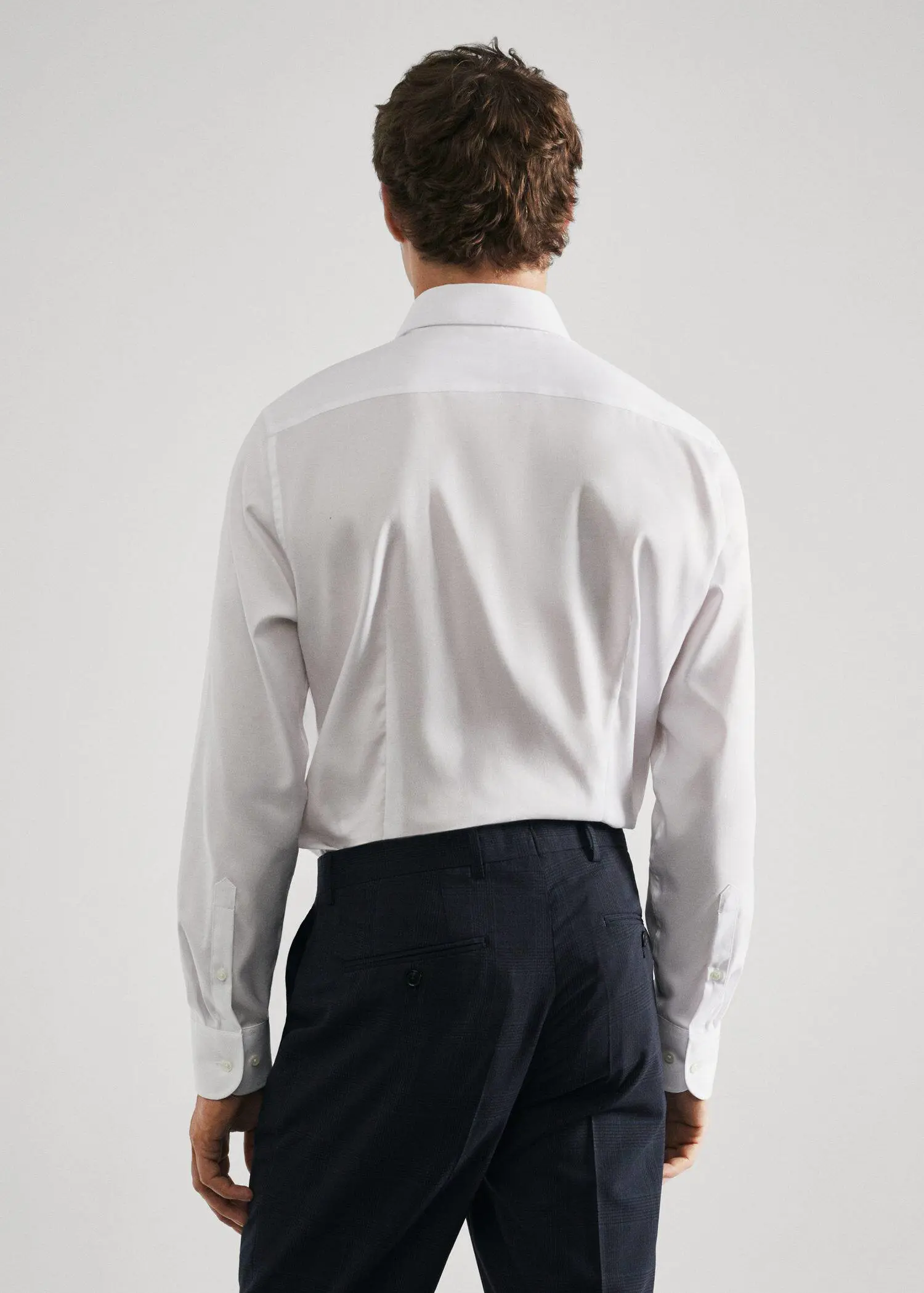 Mango Slim-fit textured cotton suit shirt. a man wearing a white shirt and black pants. 
