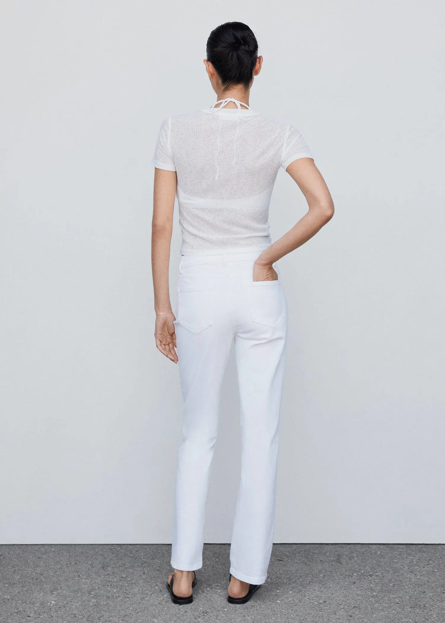 Mango Medium-comfort straight jeans. a woman wearing all white standing in front of a white wall. 