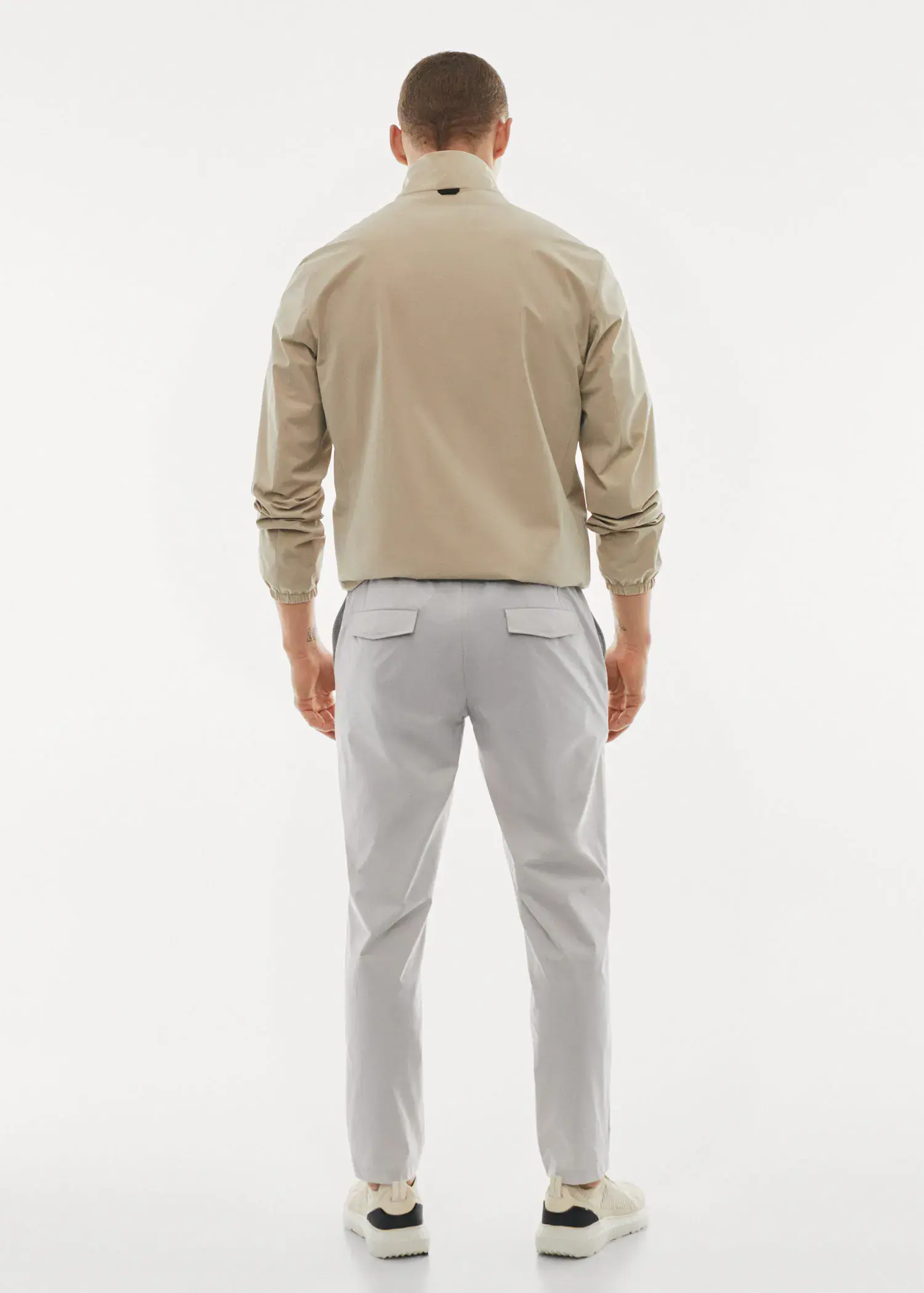 Mango Water-repellent technical trousers. a man in a tan jacket and white pants. 