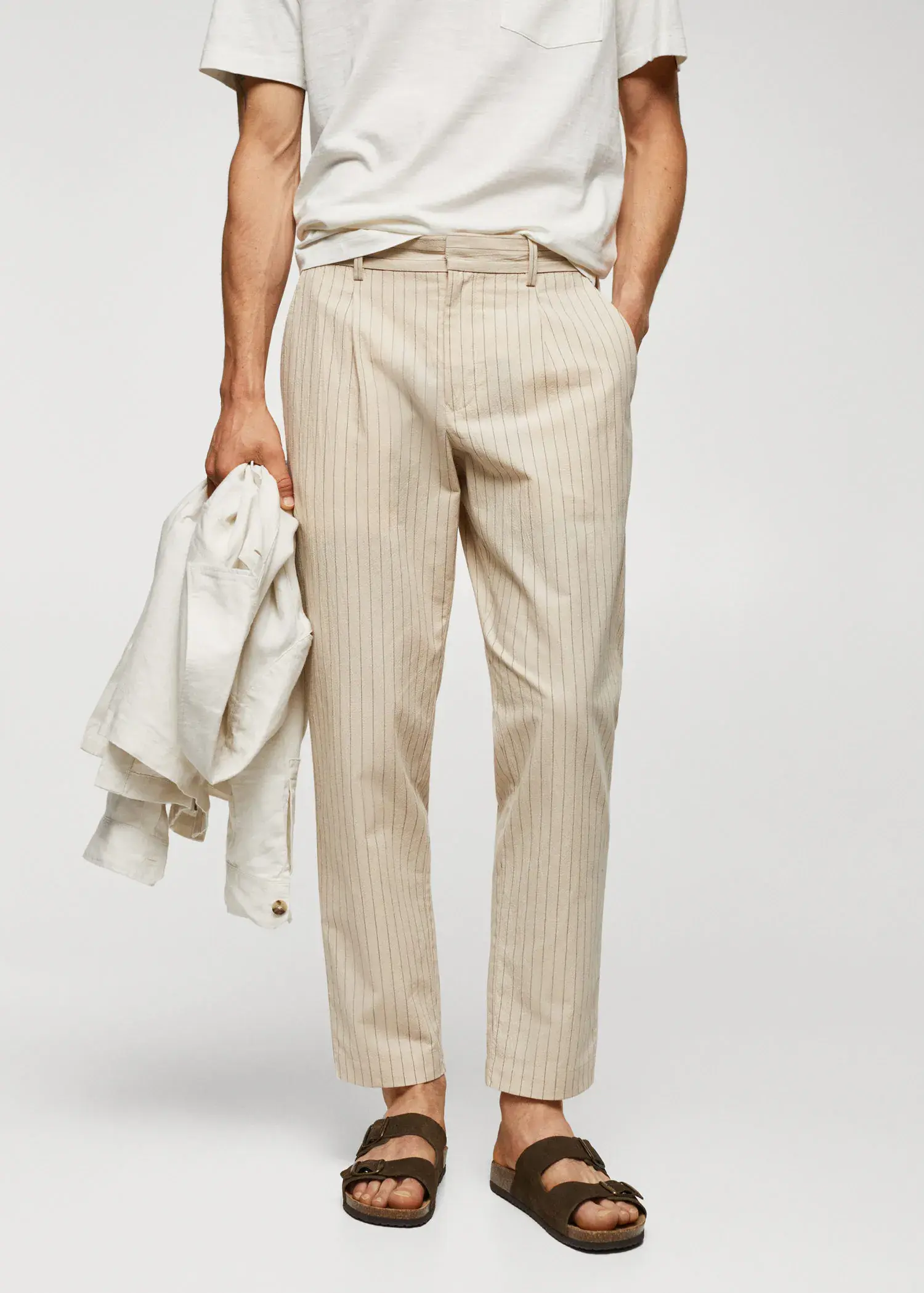 Mango Cotton-linen seersucker pants. a man wearing a white shirt and beige striped pants. 
