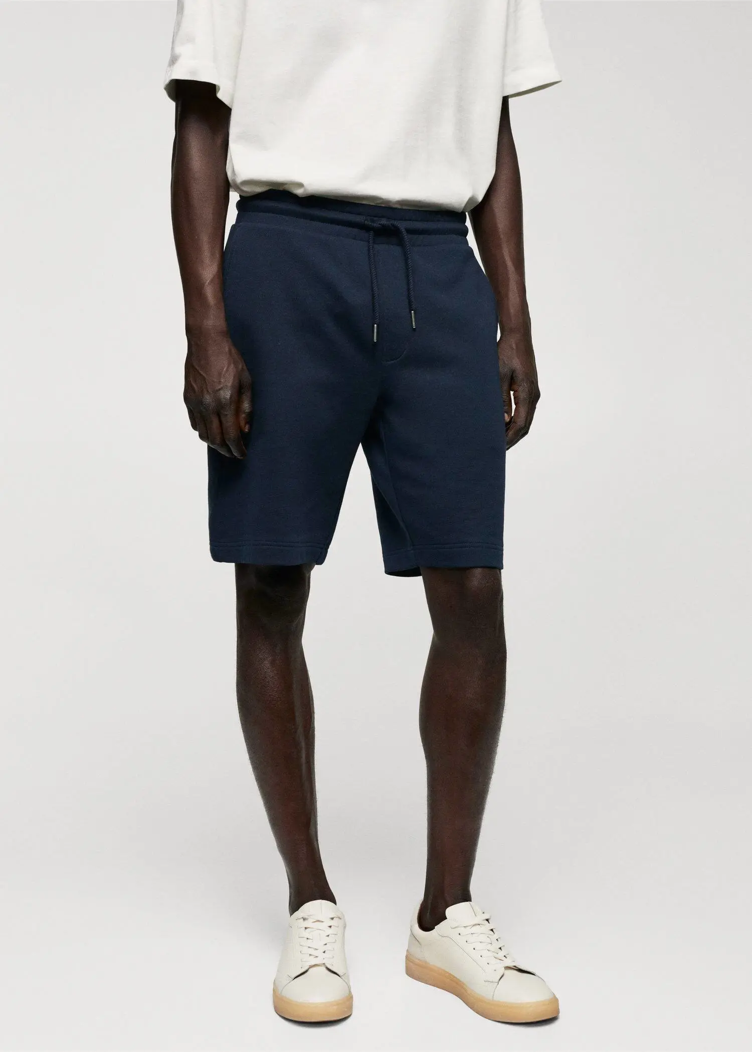Mango Jogger cotton Bermuda shorts. a man wearing a pair of blue sweat shorts. 