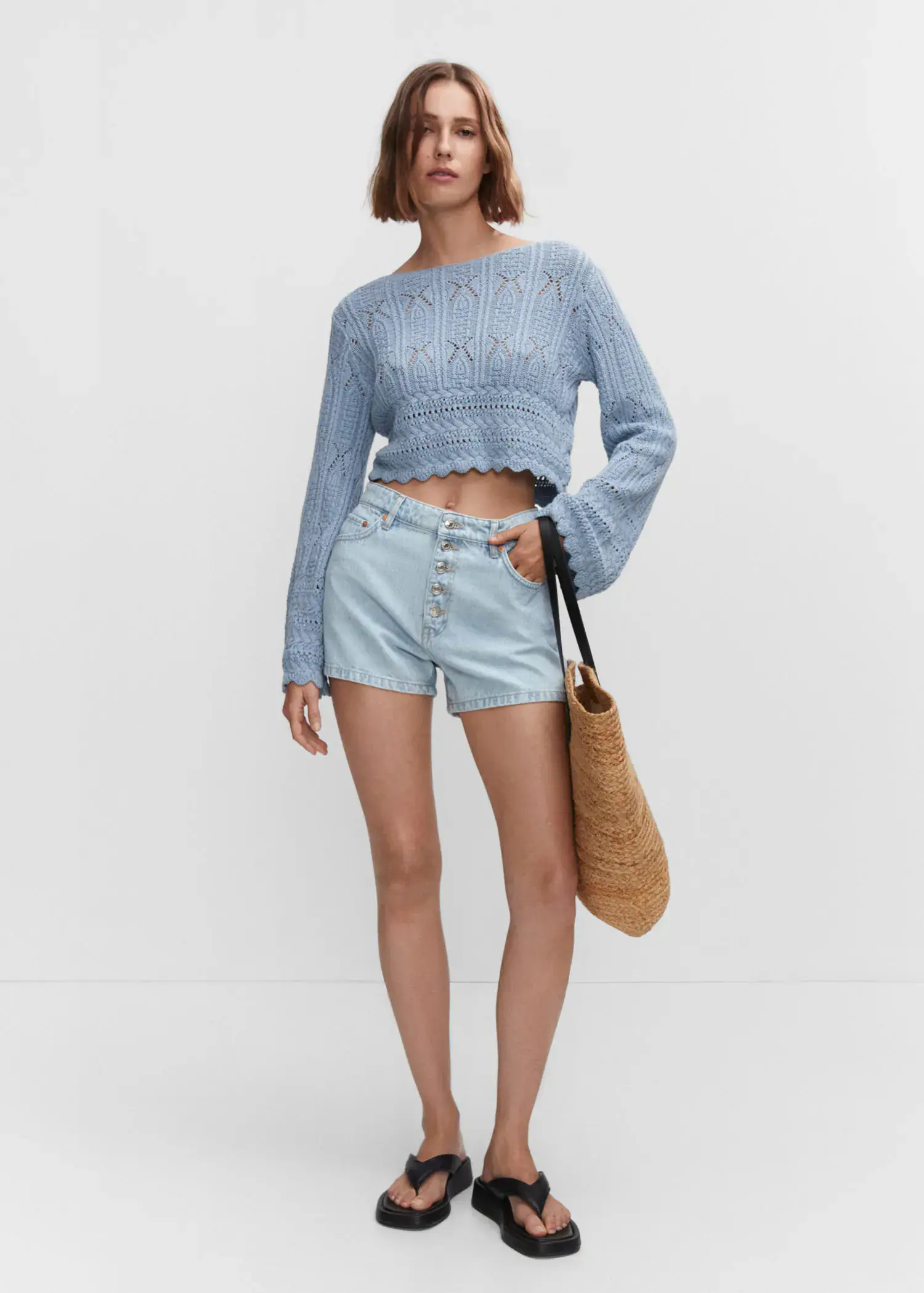 Mango Denim shorts with buttons. a woman in a blue sweater and shorts holding a bag. 