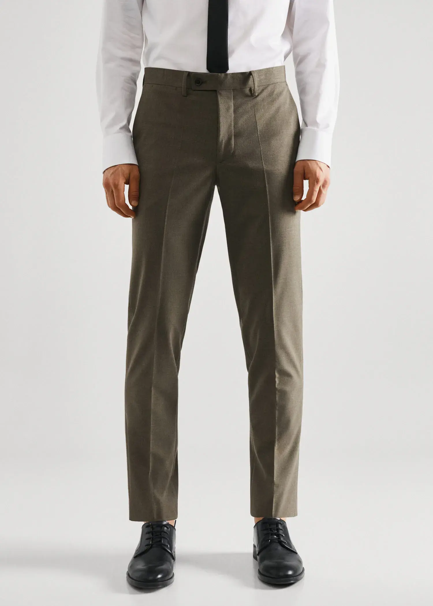 Mango Stretch fabric slim-fit suit trousers. a man wearing a suit standing in front of a white wall. 