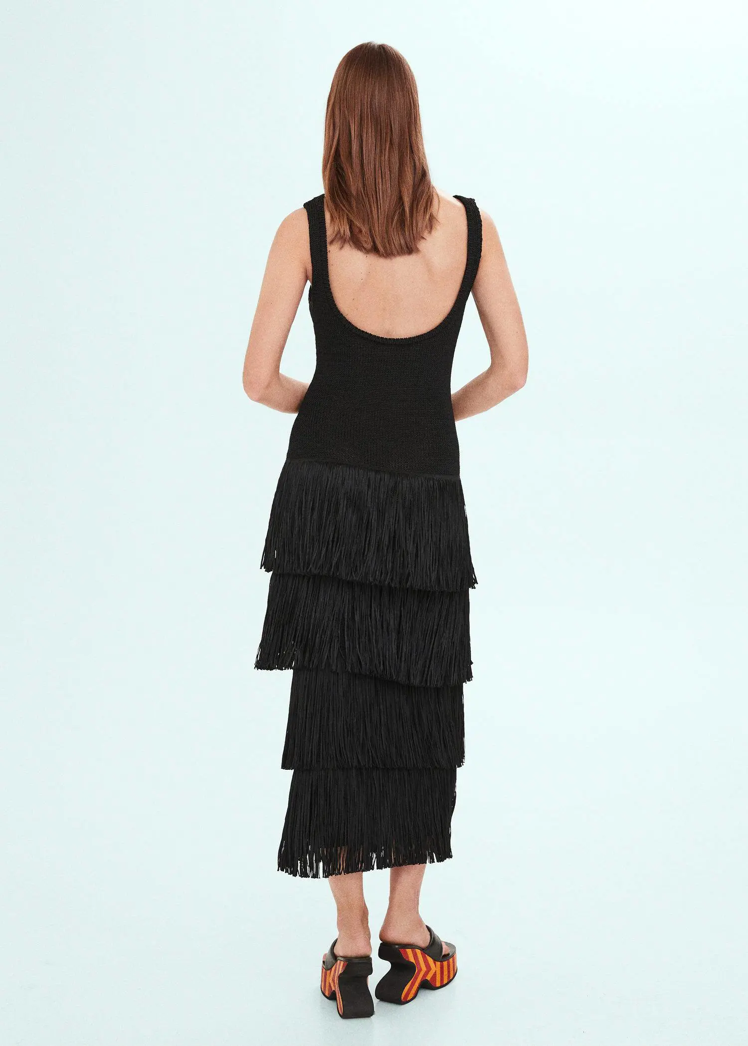 Mango Knitted dress with fringe design. a woman wearing a black dress with fringes. 