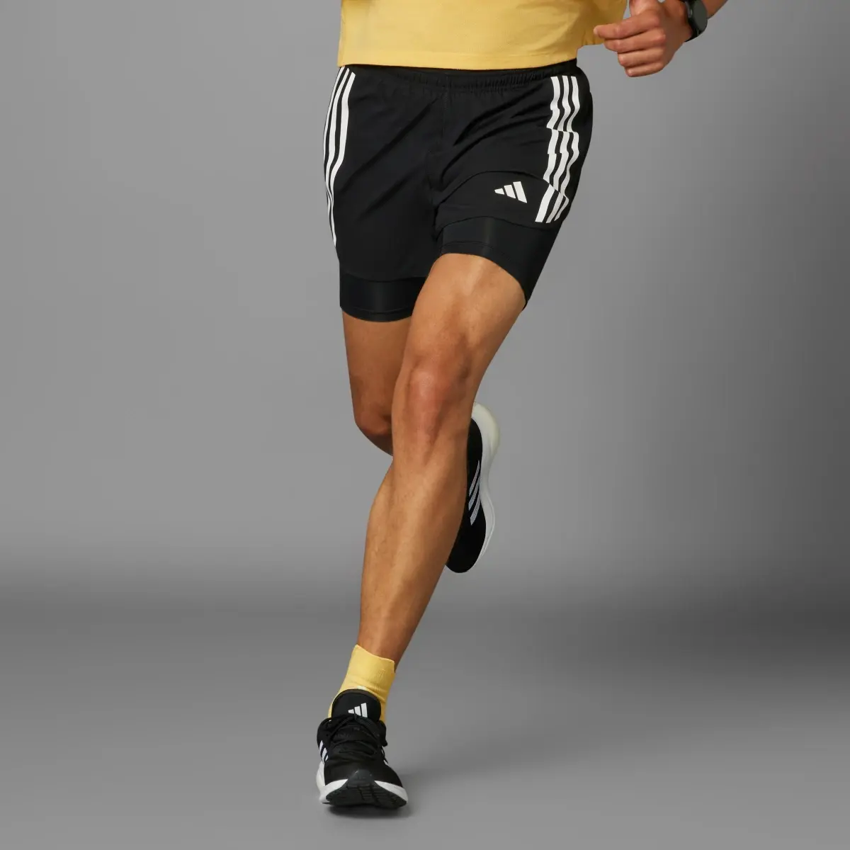 Adidas Own the Run 3-Streifen 2-in-1 Shorts. 1