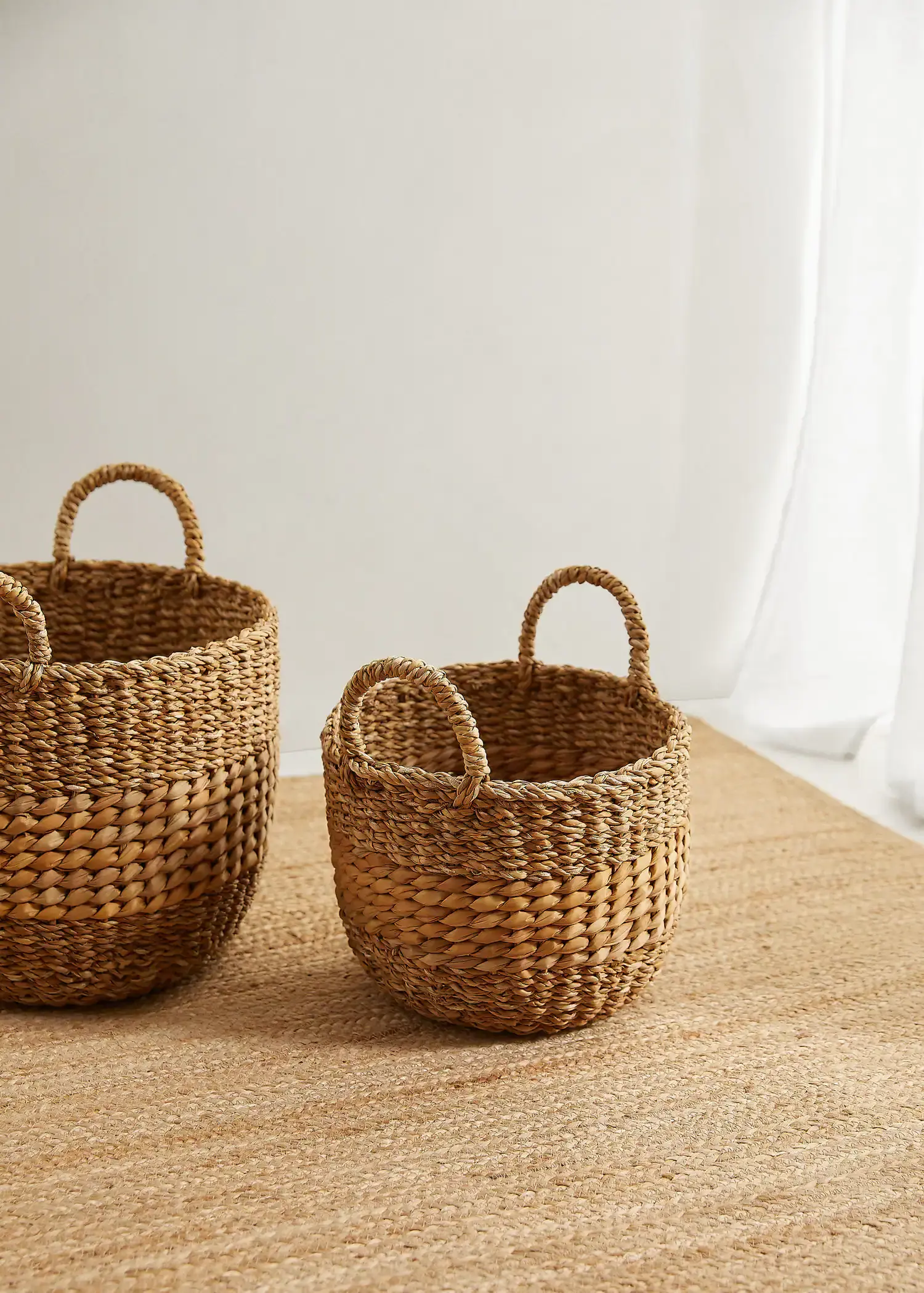 Mango Round basket 28x20x22cm. two baskets sitting side by side on top of a table. 