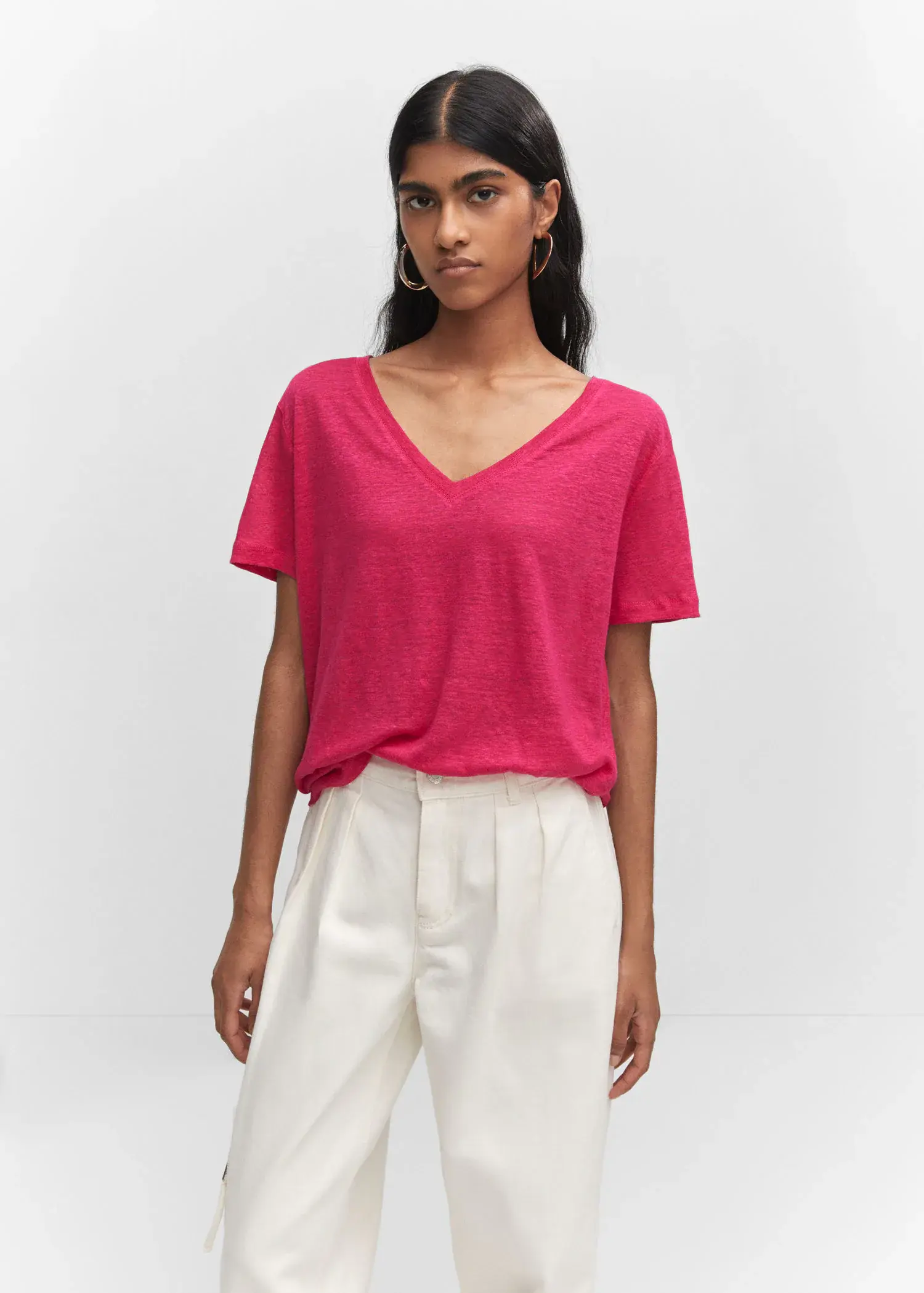 Mango V-neck linen t-shirt. a woman wearing a pink shirt and white pants. 