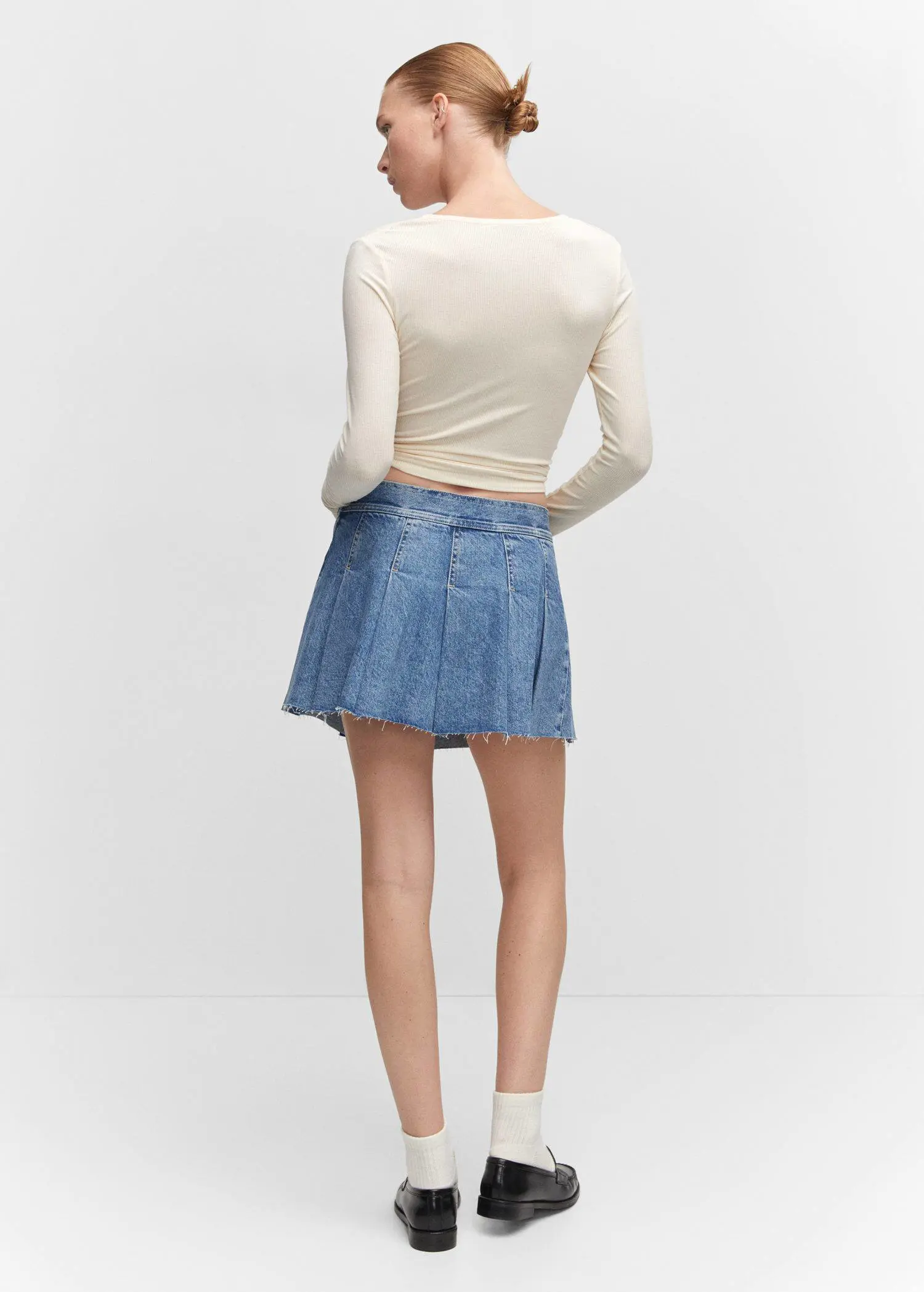 Mango Denim mini-skirt. a woman wearing a white shirt and a blue skirt. 
