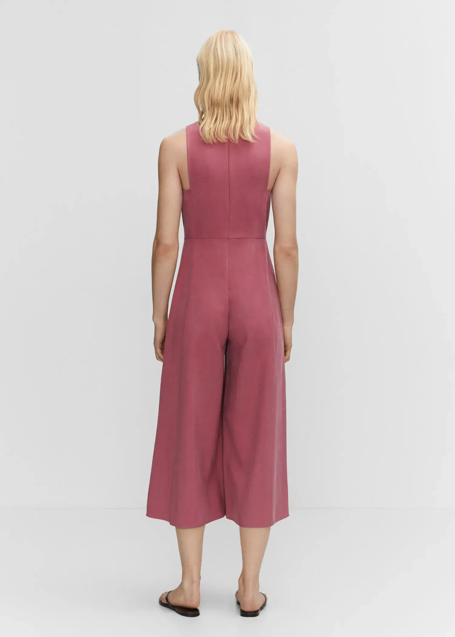Mango Cropped jumpsuit with straps. a person wearing a pink jumpsuit standing next to a white wall. 